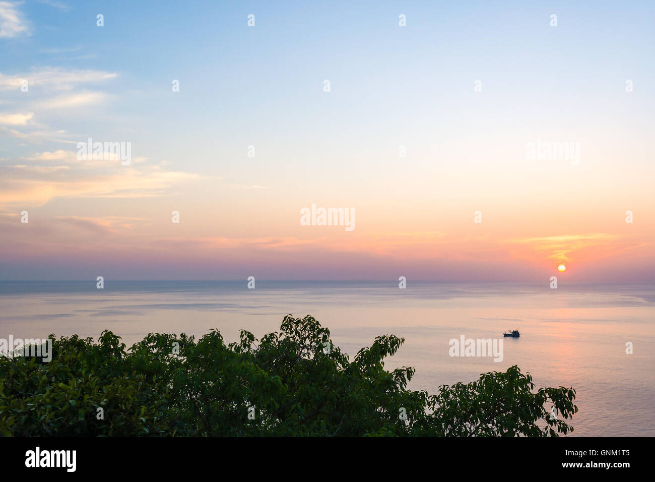 Wide angle seascape view of a boat on sunset. Stock Photo