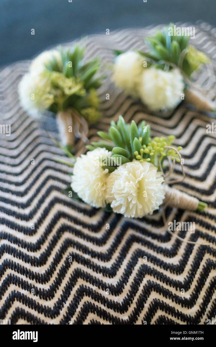Boutonniere for groom and groomsman on black and white wavy stripes pattern fabric. Stock Photo