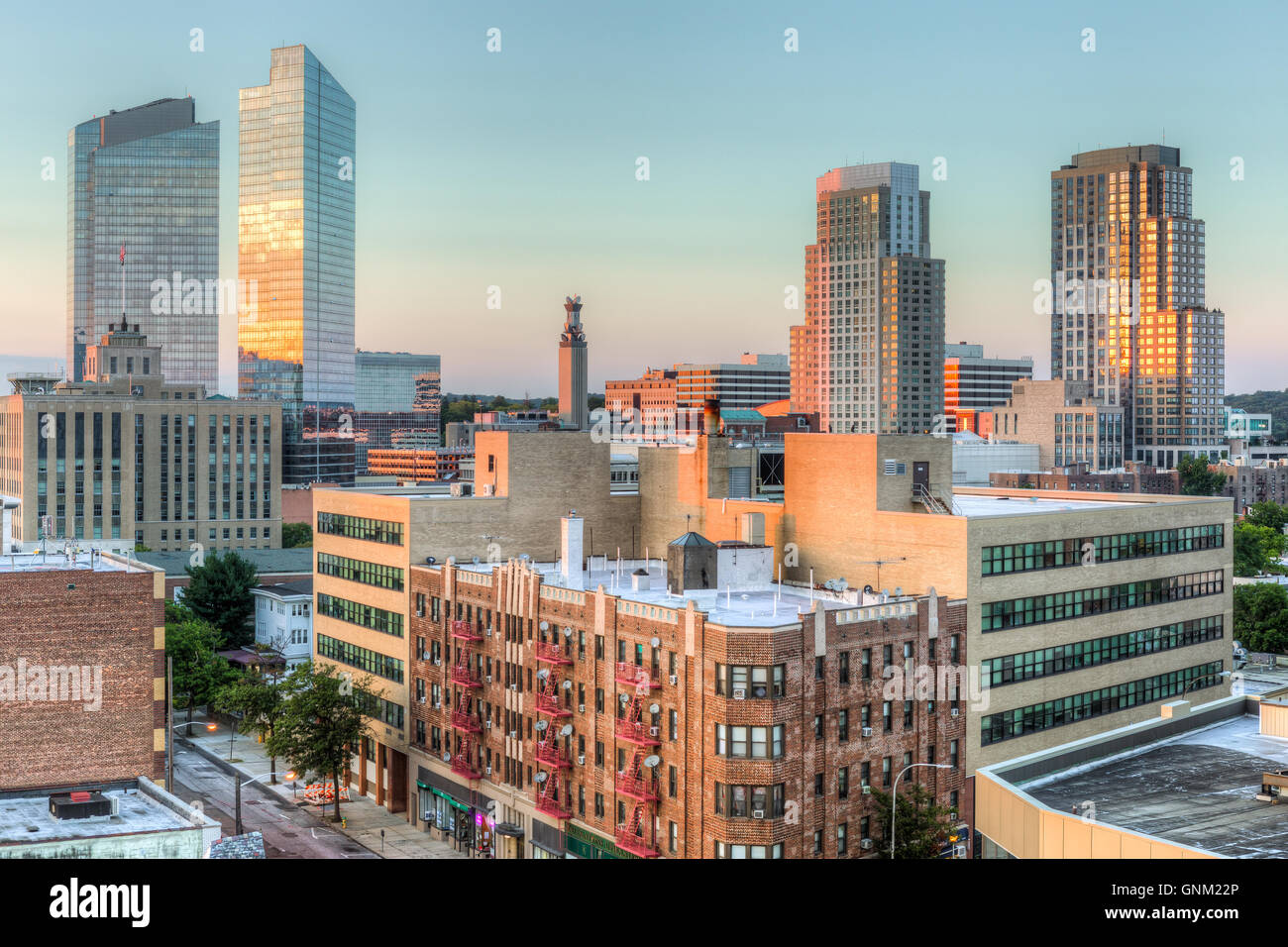 Orange colors from the western sky reflect off the buildings in the skyline shortly before sunset in White Plains, New York. Stock Photo