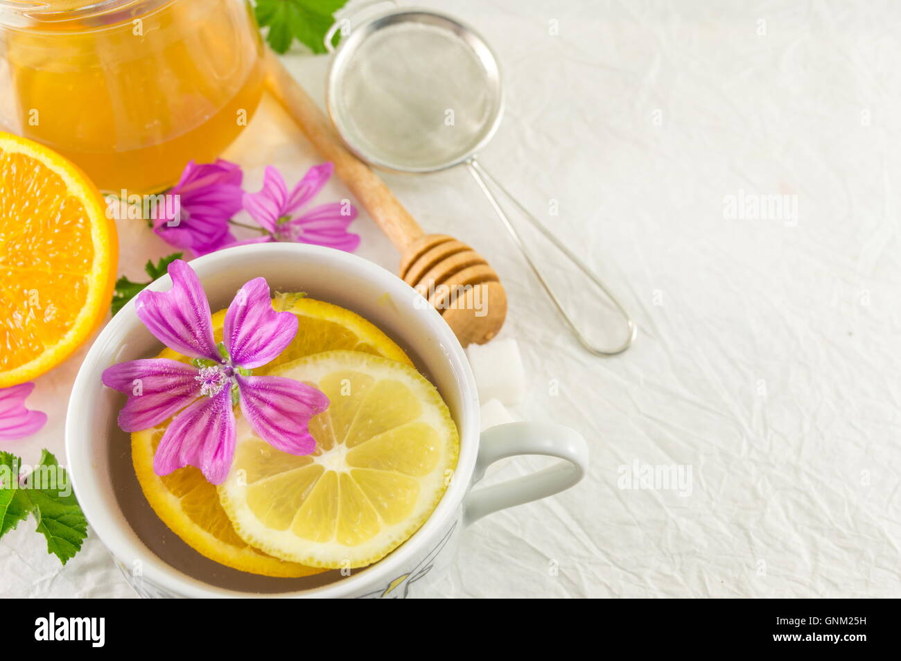 Malva sylvestris, mallow, tea with lemon and fresh flowers Stock Photo