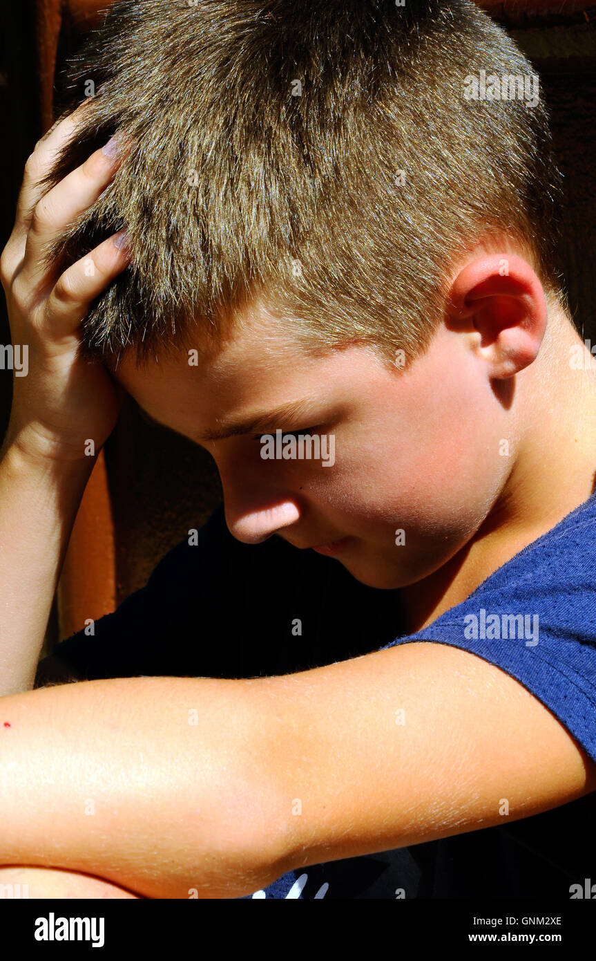 Little boy is sad and scared because he had lost a cell phone and can not play games Stock Photo