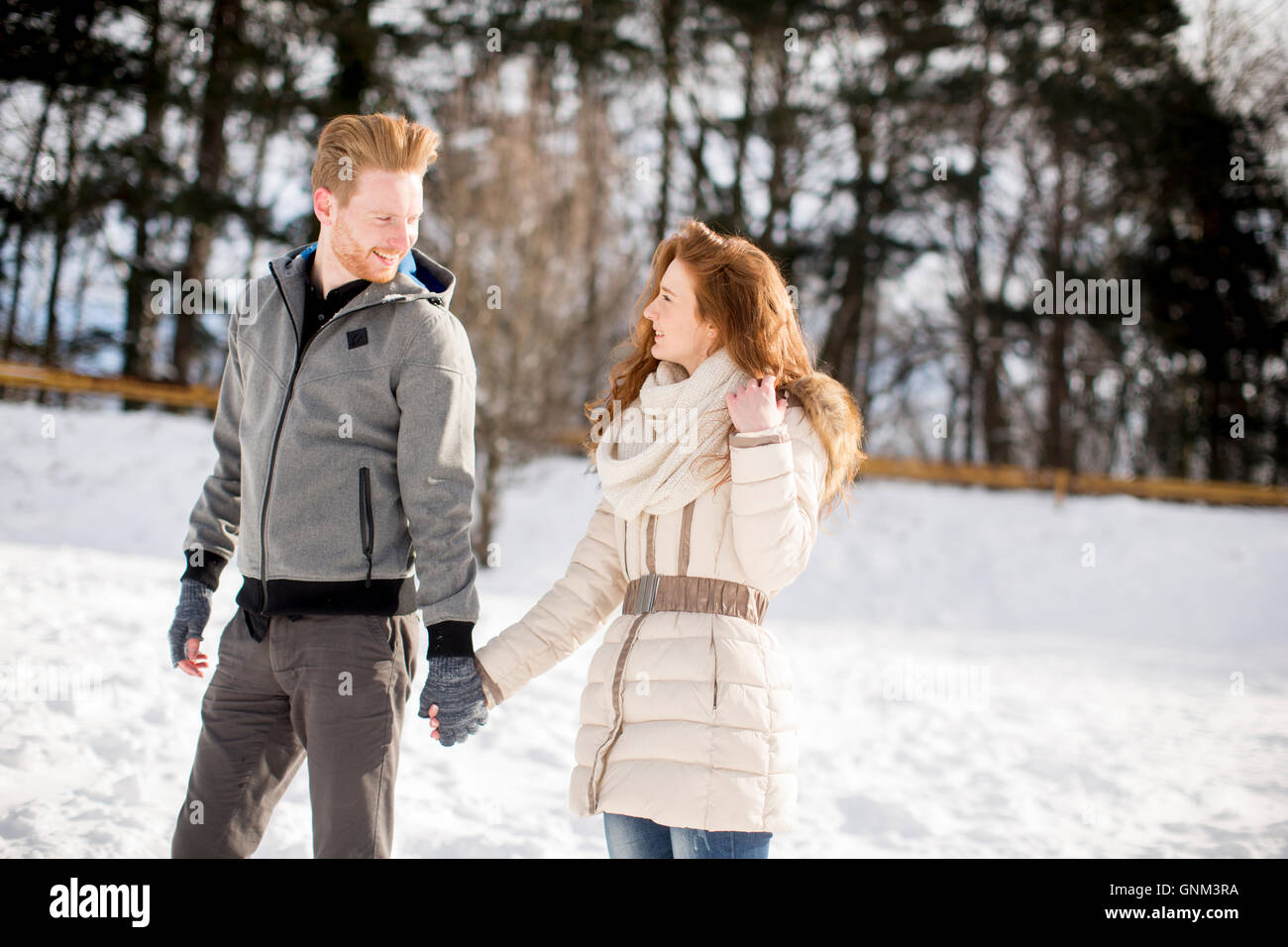 Loving young couple at snow in the winter forest Stock Photo