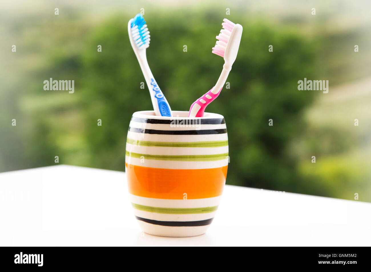 Tooth brushes in glass, his and hers Stock Photo