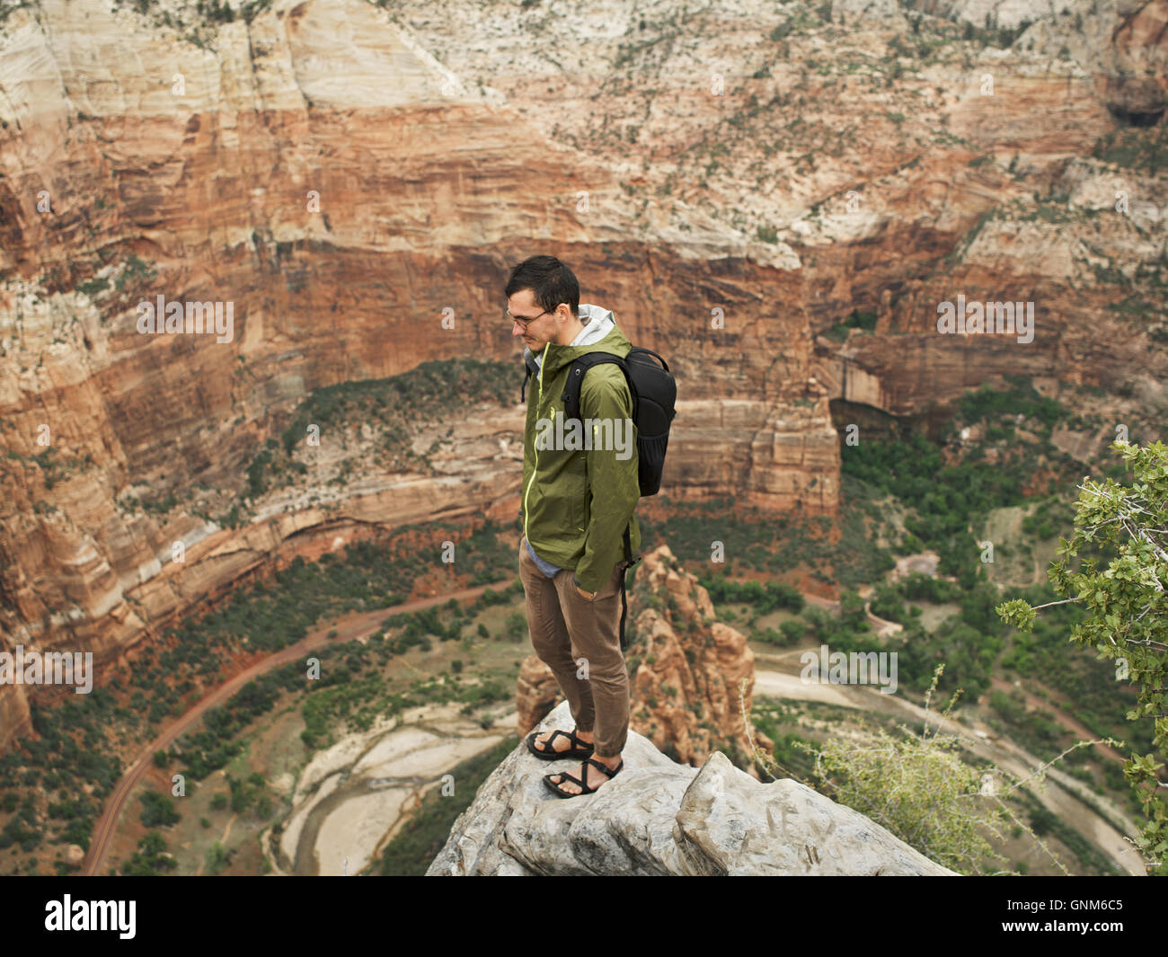 A hiker stands at the top of a peak in Utah's Zion National Park Stock Photo