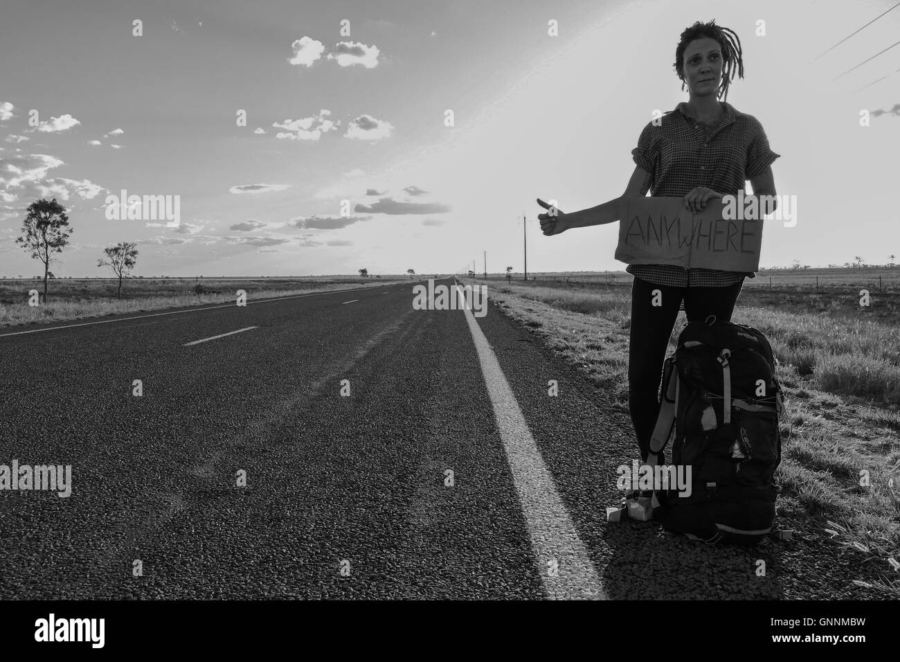 Backpacker girl/ Hitchhiker on a endless road in Queensland Australia