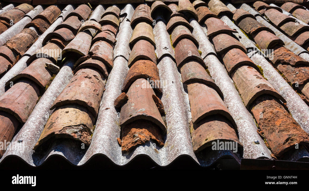 Roof in dangerous asbestos and old tiles Stock Photo