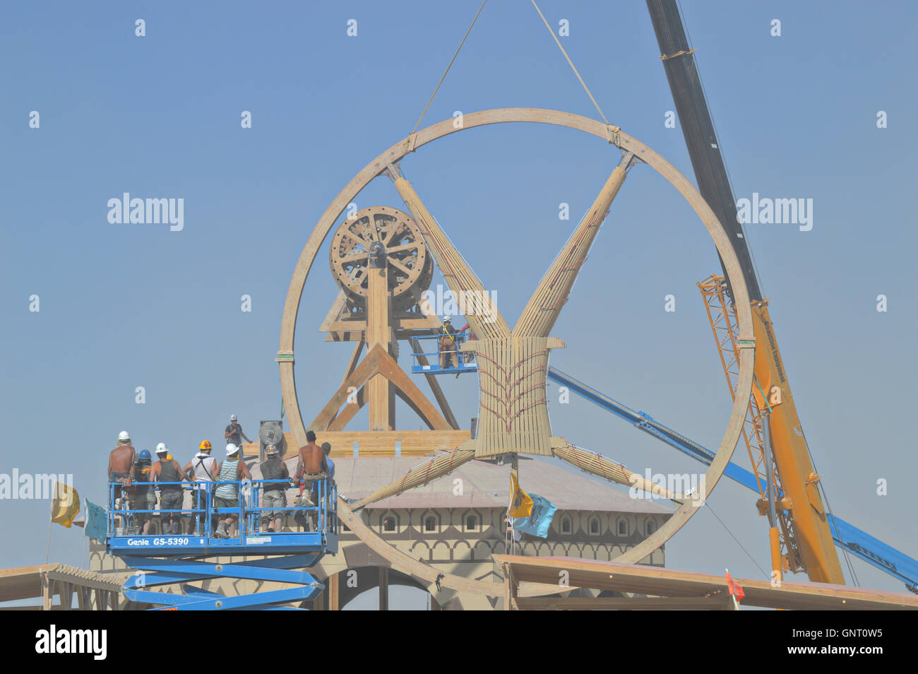 Construction cranes lift the giant effigy during set up for the annual desert festival Burning Man August 28, 2016 in Black Rock City, Nevada. Stock Photo