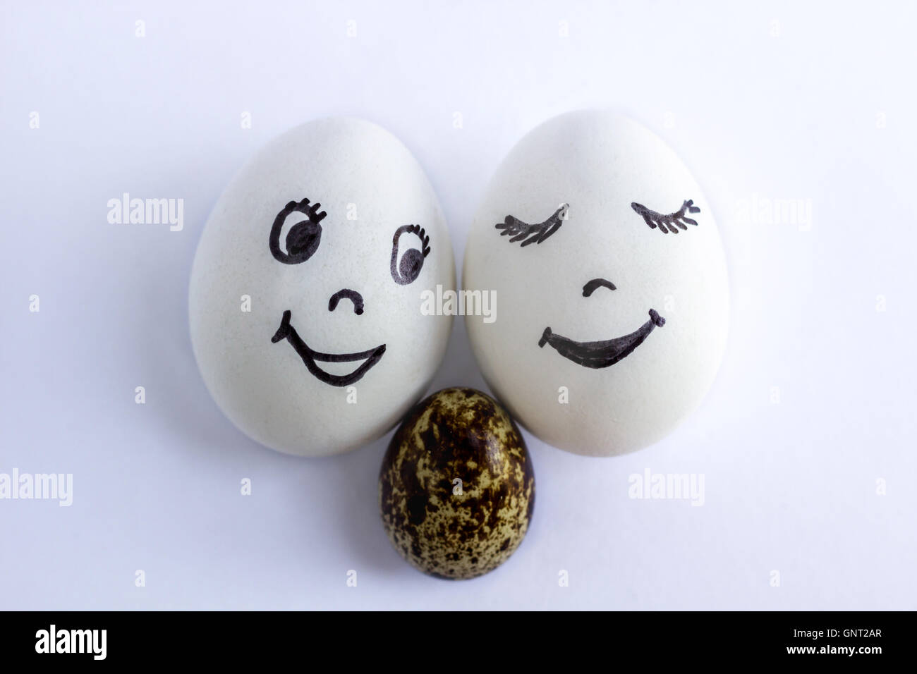 Funny eggs imitating a happy smiling family with baby on white
