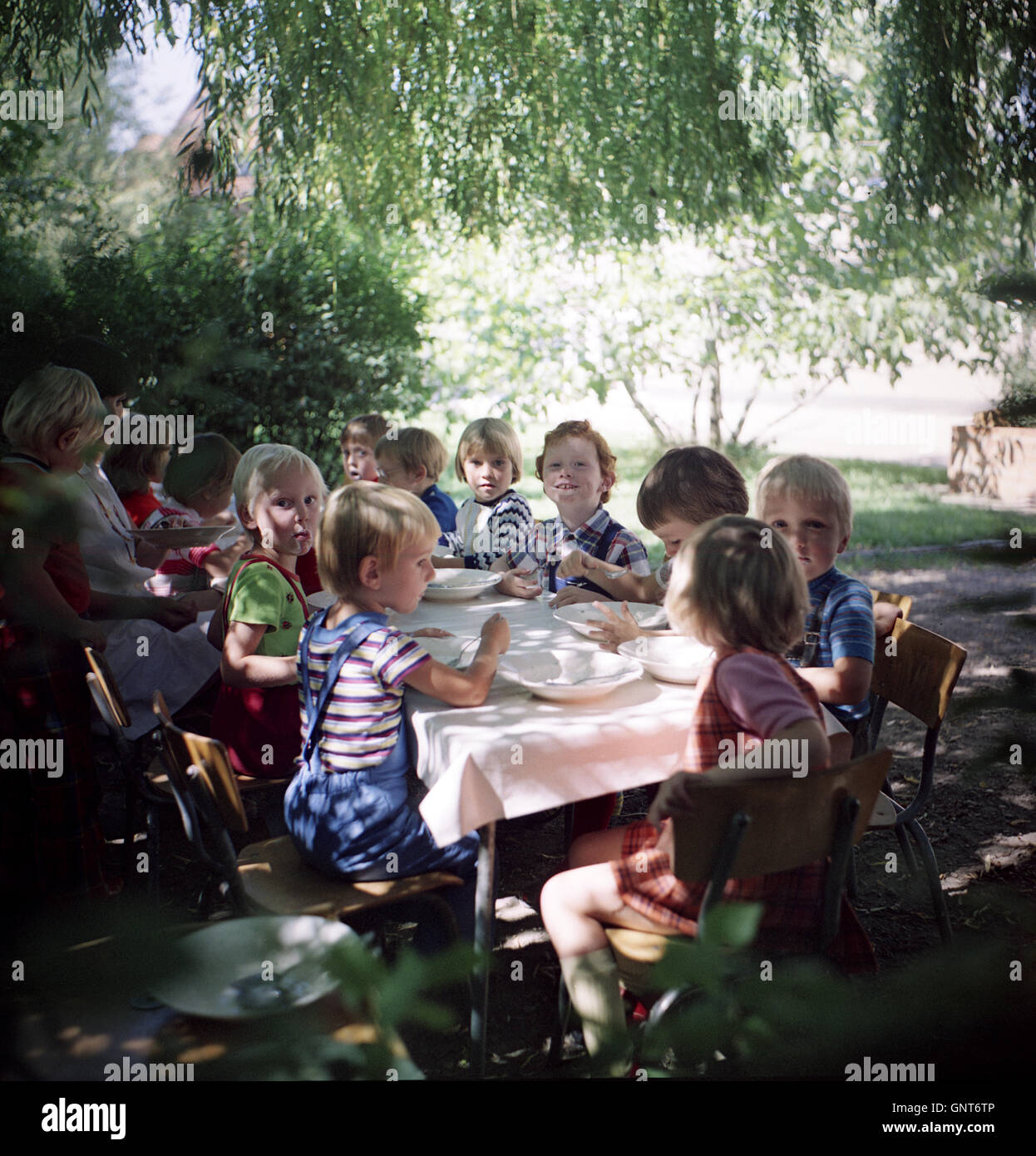 Rostock, DDR, kindergarten children sit to eat at a table Stock Photo
