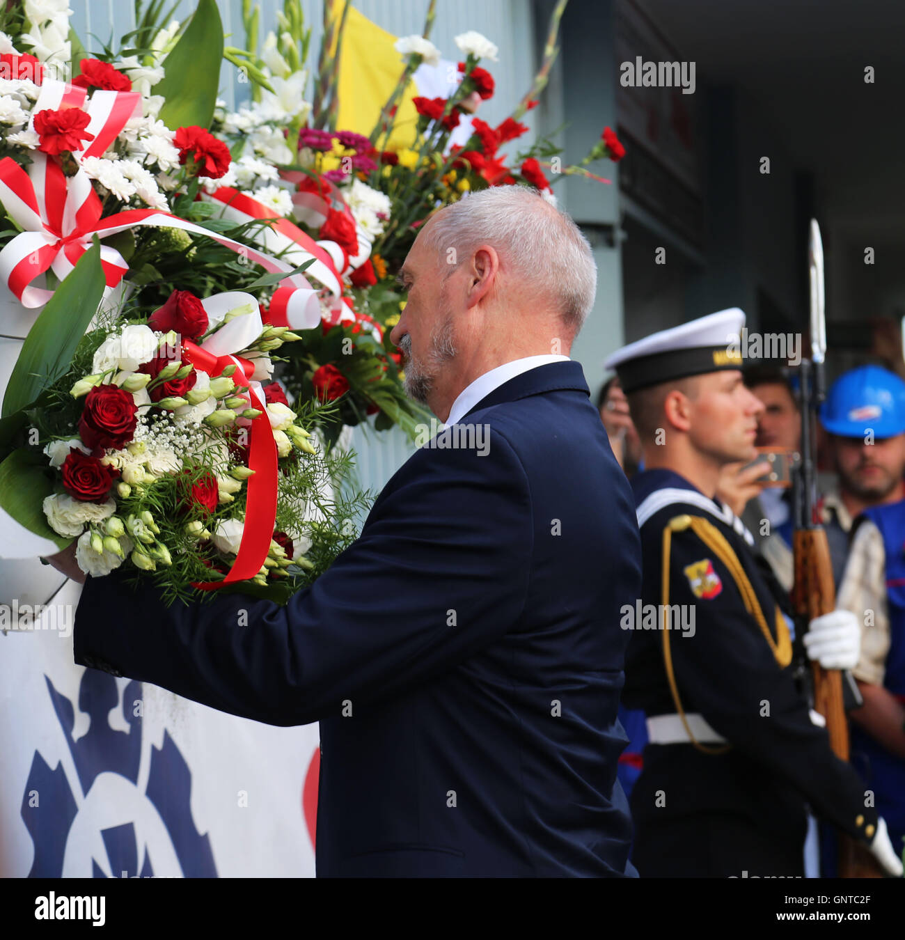 Polish Minister of Defense, Antoni Macierewicz, laid flowers in front of the Number 2 gate of the Gdansk shipyard during the 36th anniversary of the signing of the August agreements in Gdansk, Poland. Gate Number 2 of the Gdansk shipyard is the same gate from which Lech Walesa, the legendary leader of the Solidarity movement announced the termination of the strike and the signing of the August Agreements. However, former President Lech Walesa was not in attendance due to the political infighting and accusations that have been directed at him from the current governing party. The August agreeme Stock Photo