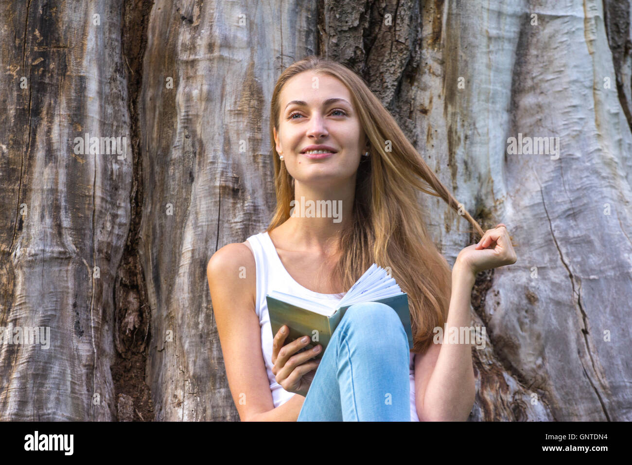 Young woman sitting on the grass and reading book outdoor Stock Photo ...