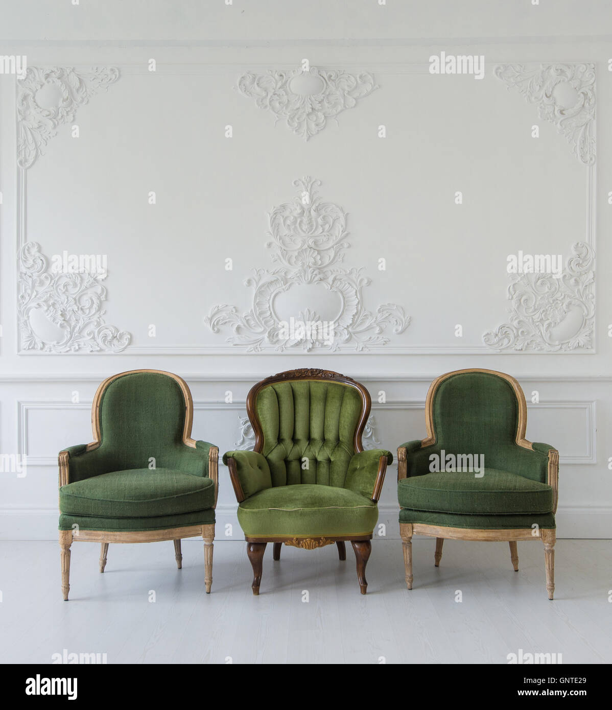 Set Of Green Wooden Vintage Chairs Standing In Front A White Wall