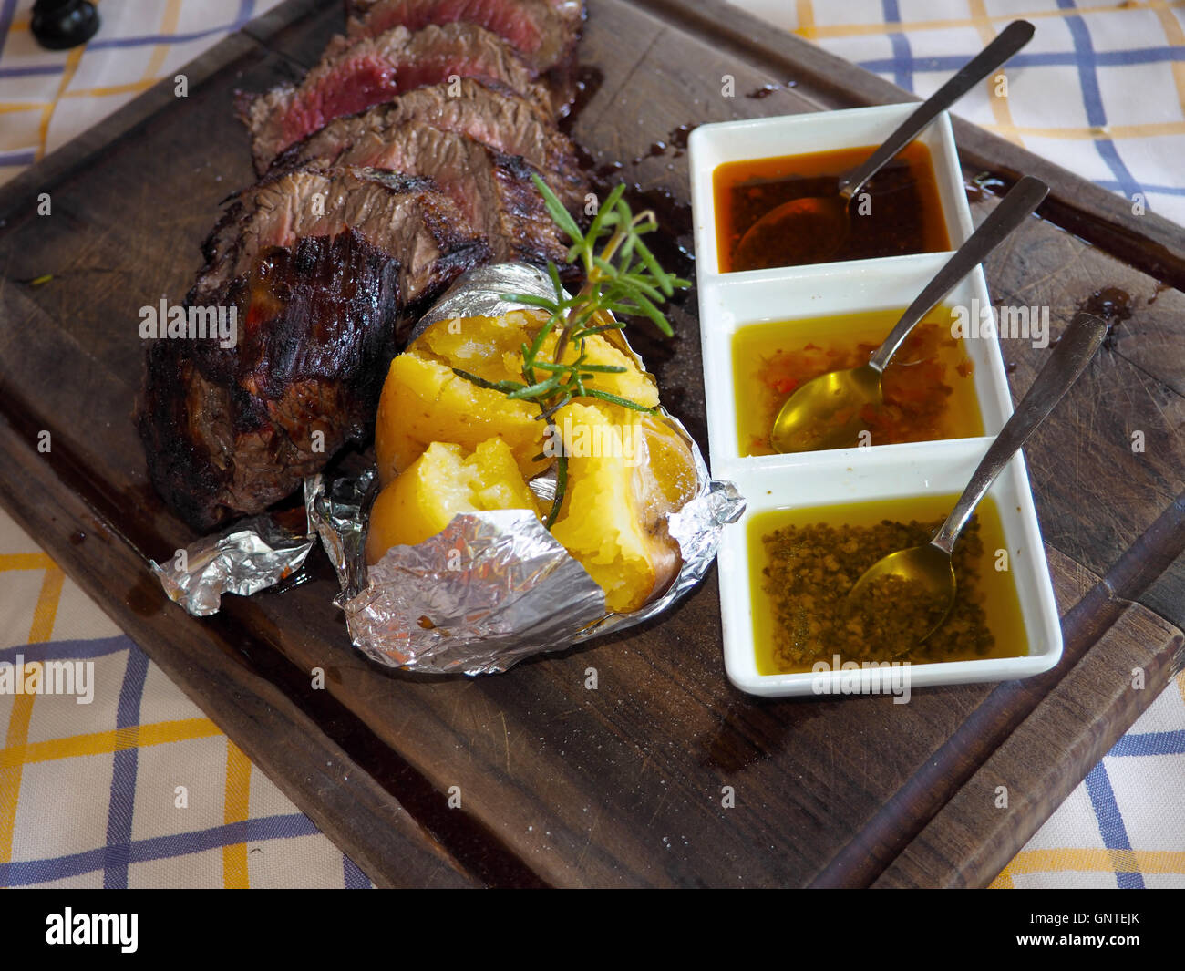 chateaubriand steak and jacket potato with olive oils presented on a