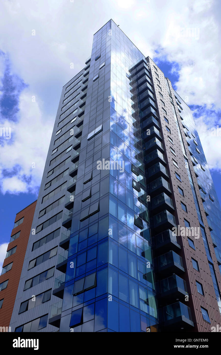 Modern high rise apartment block rises into the sky, reflecting the ... - Modern High Rise Apartments With Glass Doors