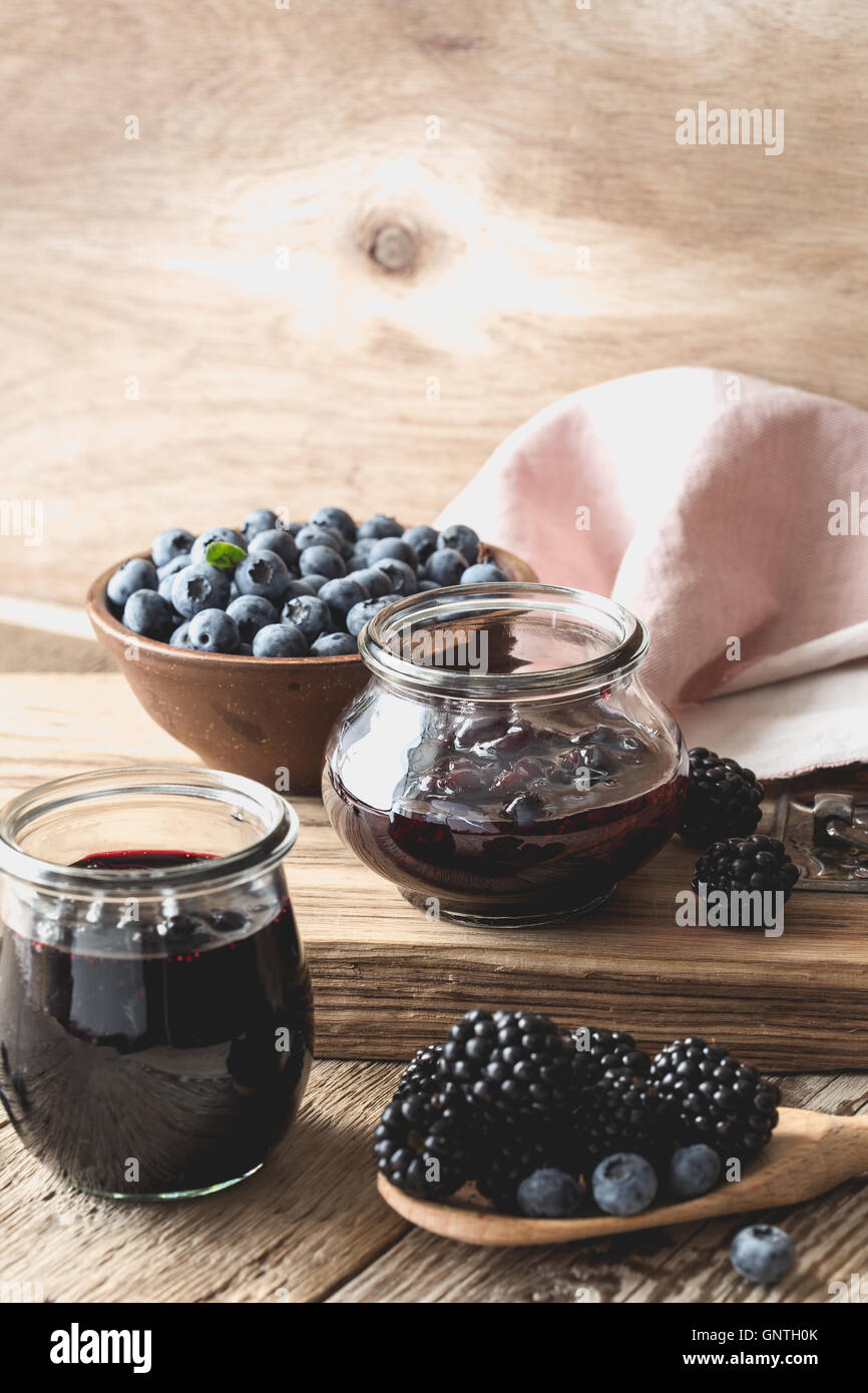 Homemade blueberries and blackberries jam in glass jars and fresh
