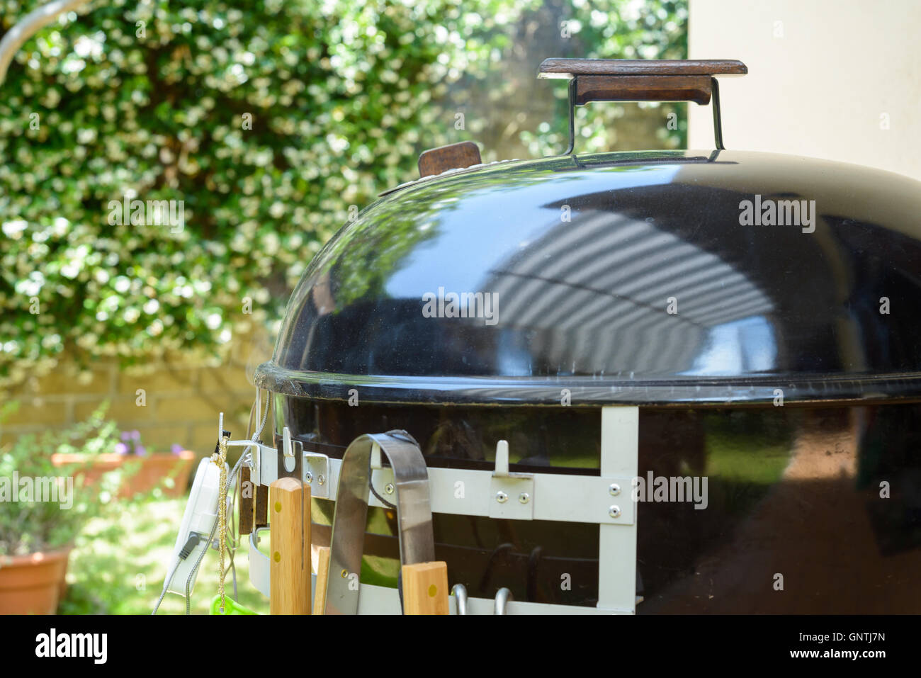 A closed barbecue during pulled pork cooking day, with tools Stock Photo