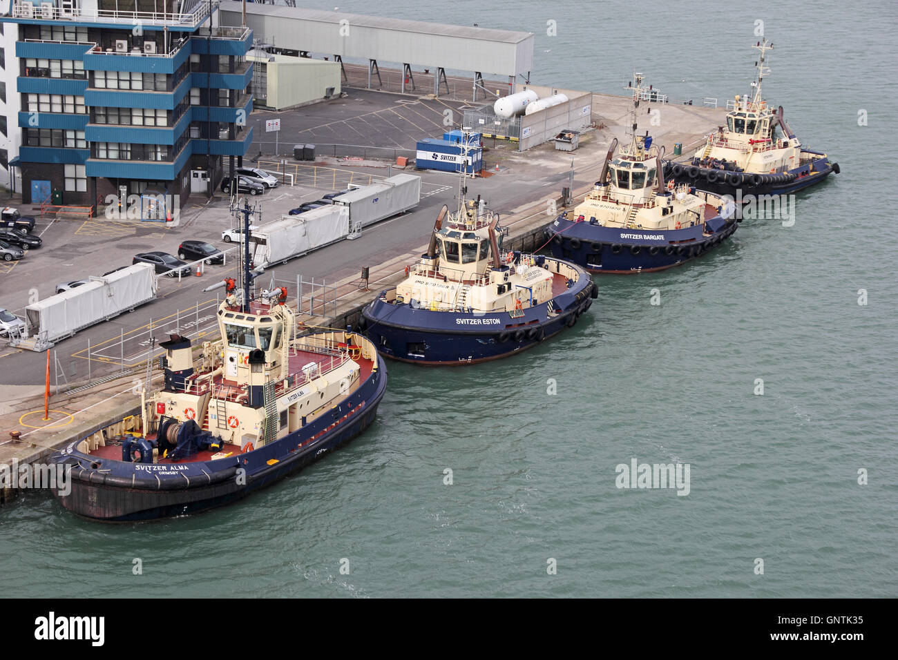 4 Svitzer tug boats moored, in line, at Southampton Docks Stock Photo