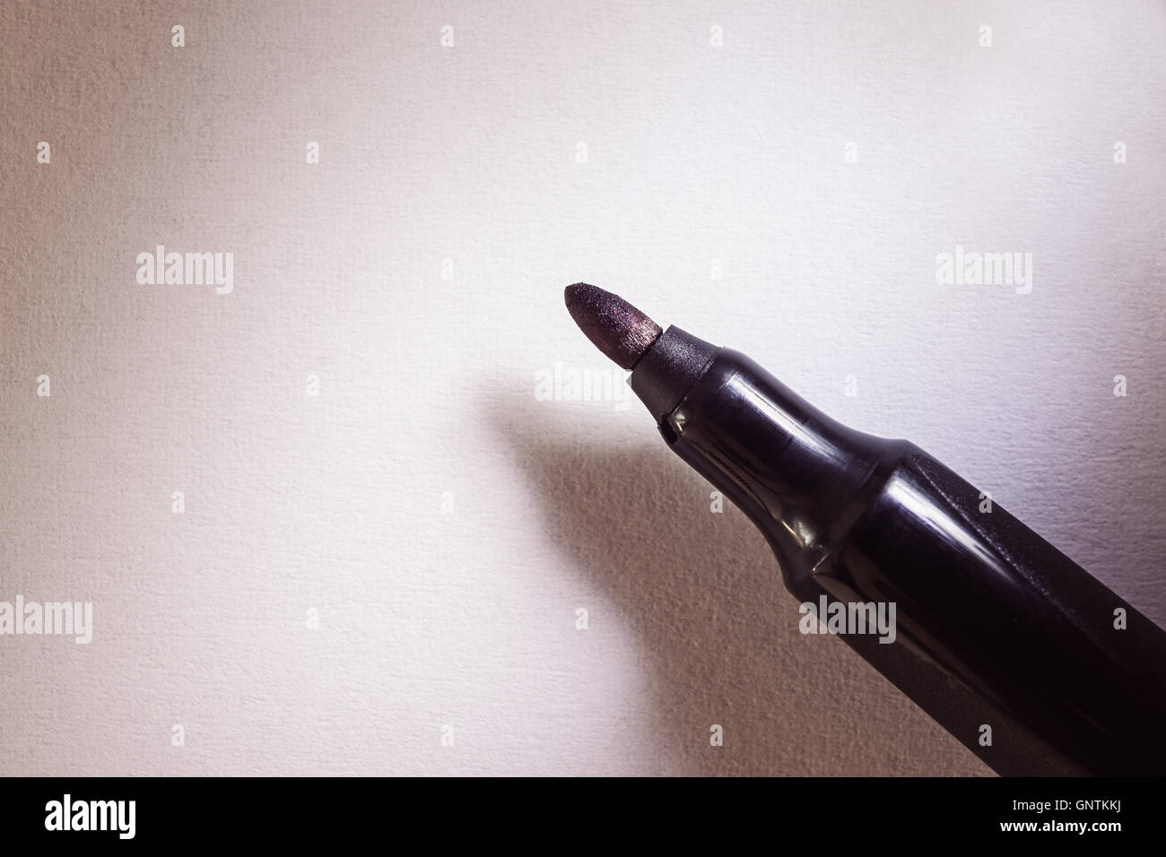 Closeup view of a black felt-tip pen on white paper. Stock Photo