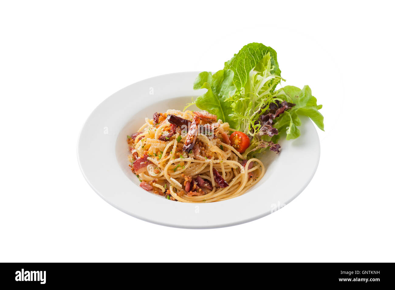 Front view of Thai, Japanese, and European fusion food style spicy pasta with bacon and dried chili in ceramic dish isolated on  Stock Photo