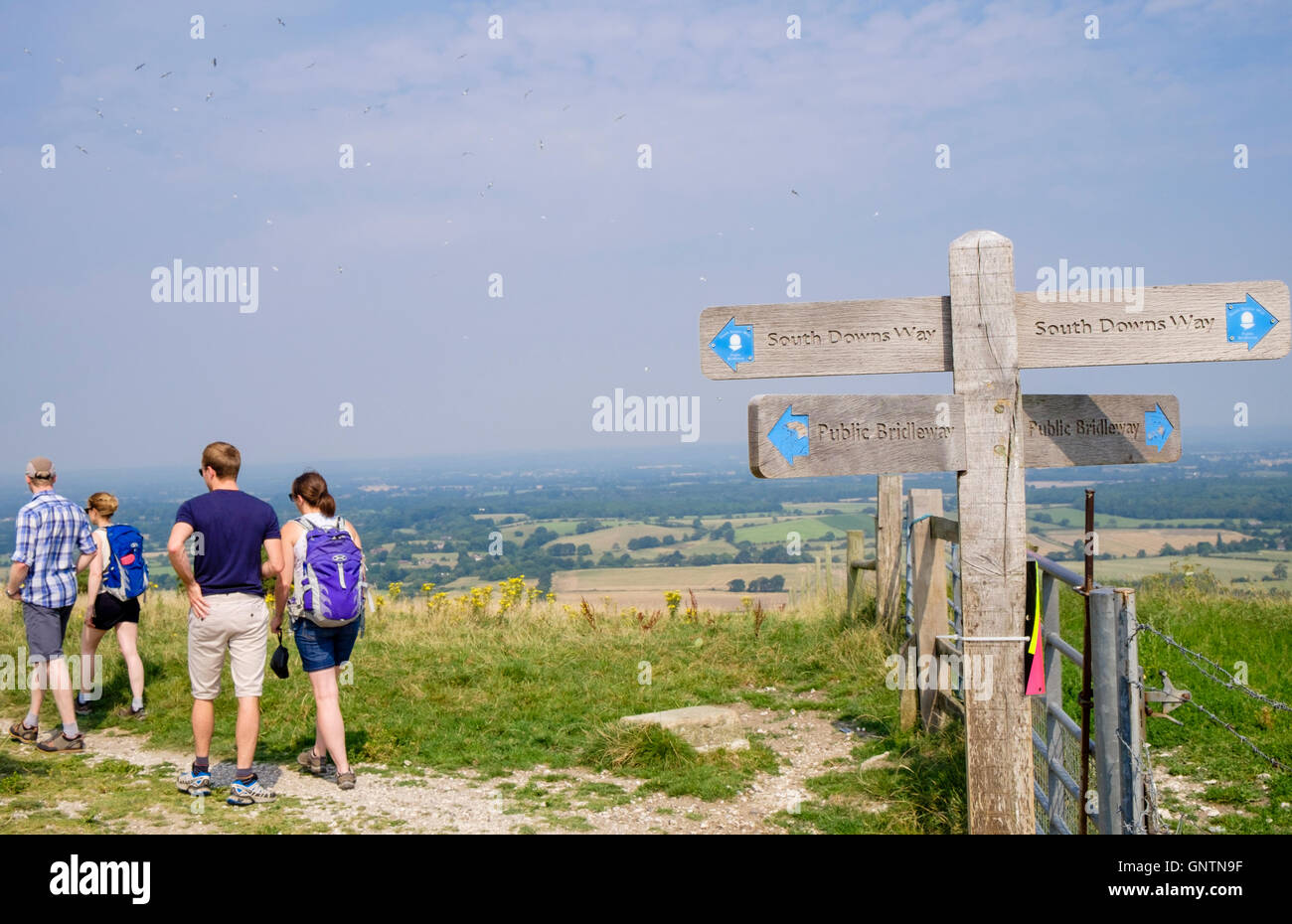 Country footpath signpost and people walking on South Downs Way trail in South Downs National Park countryside. Fulking Hill West Sussex England UK Stock Photo
