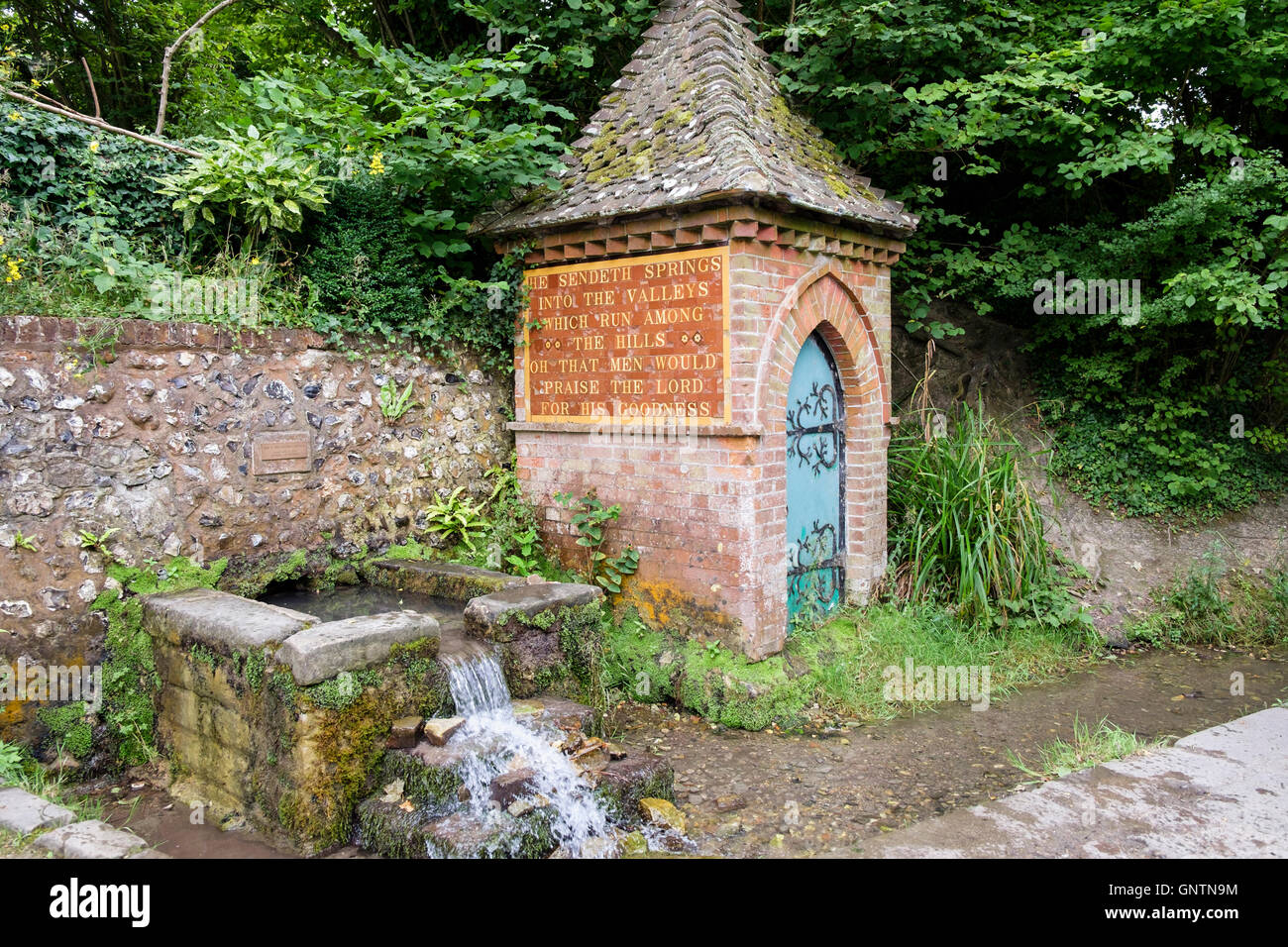 The Spring and Pump House with religious inscription in country village in South Downs National Park. Fulking Sussex England UK Stock Photo