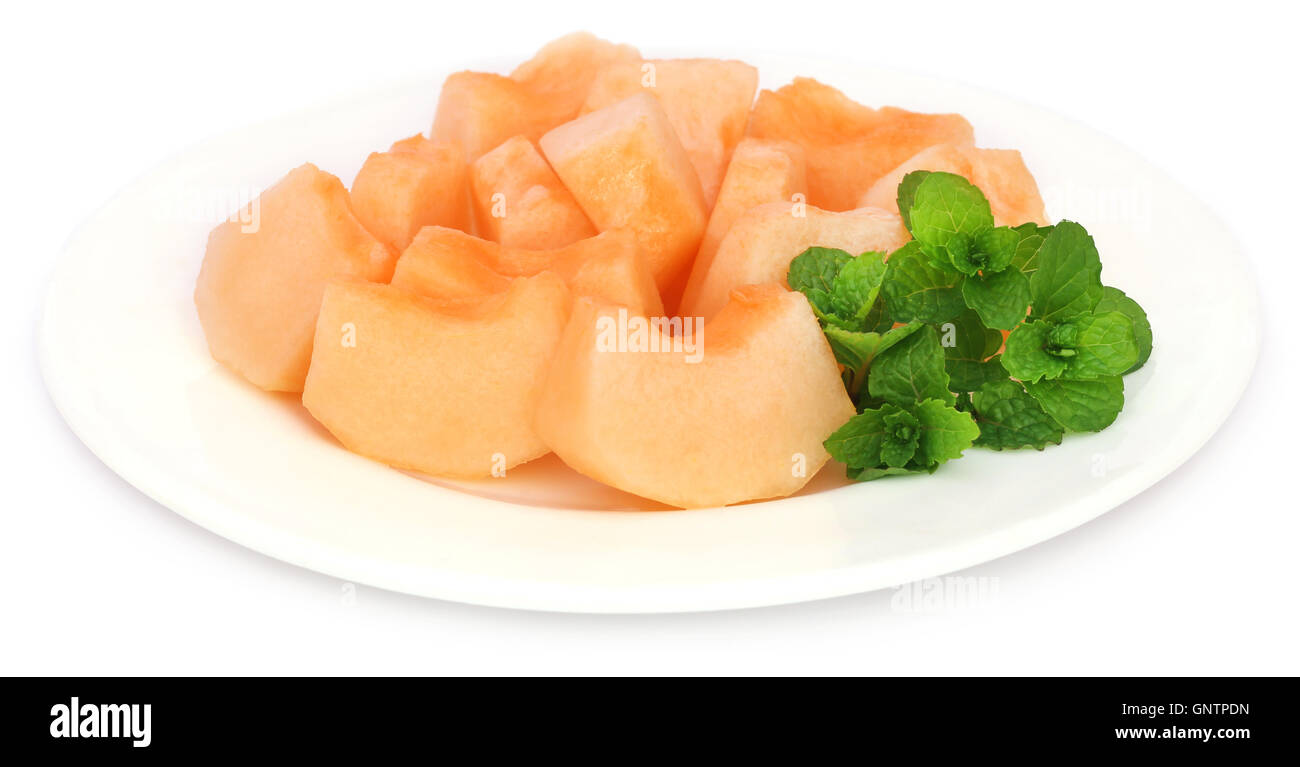 Muskmelon with mint leaves over white background Stock Photo