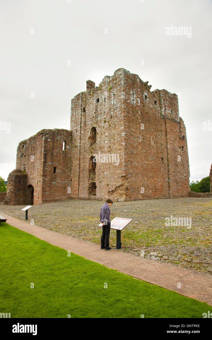 Brougham Castle keep. Woman looking at tourist sign. Penrith, Cumbria, England, United Kingdom, Europe. Stock Photo