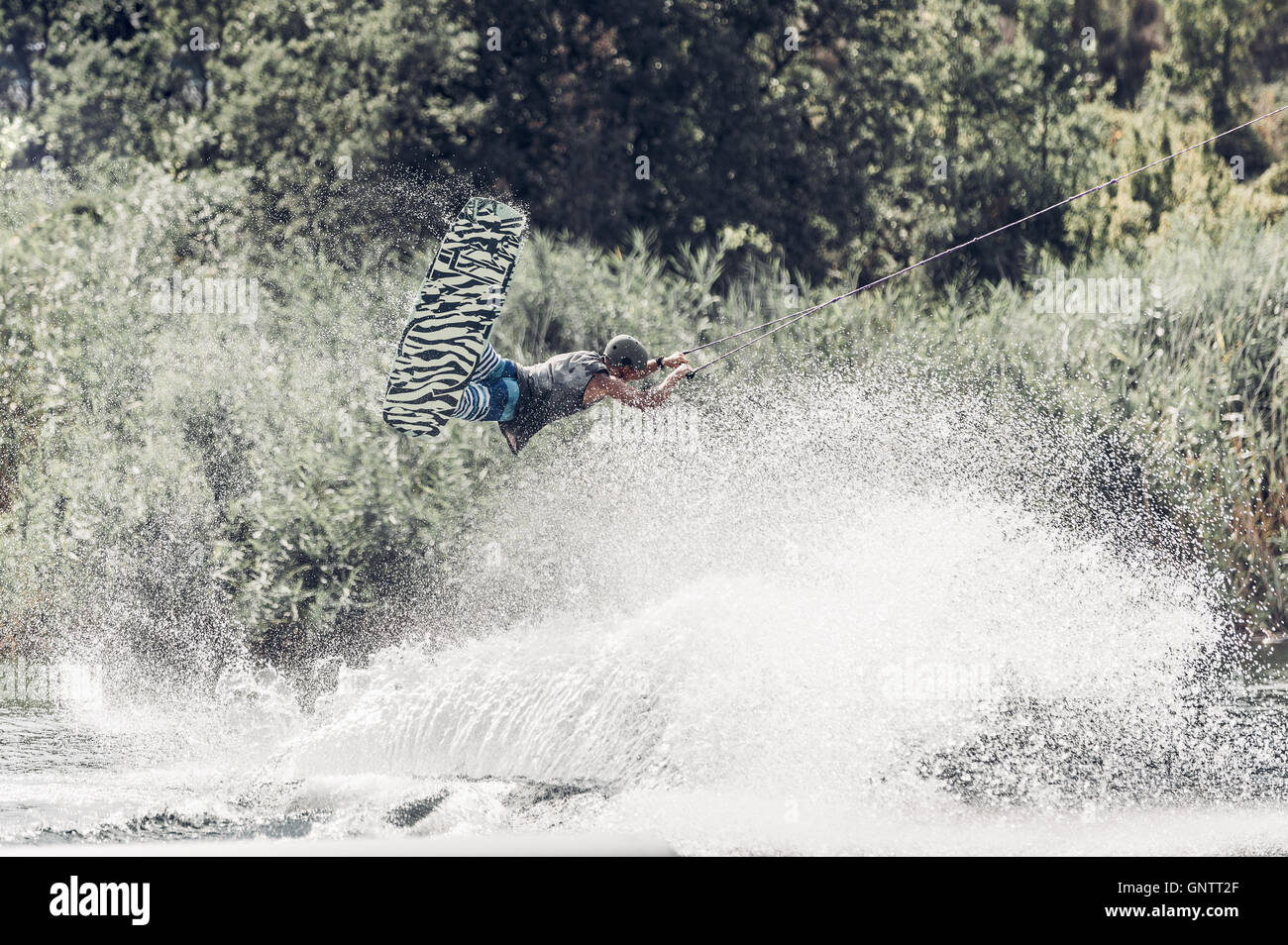 Wakeboarder jump over the lake. Tonned photo Stock Photo