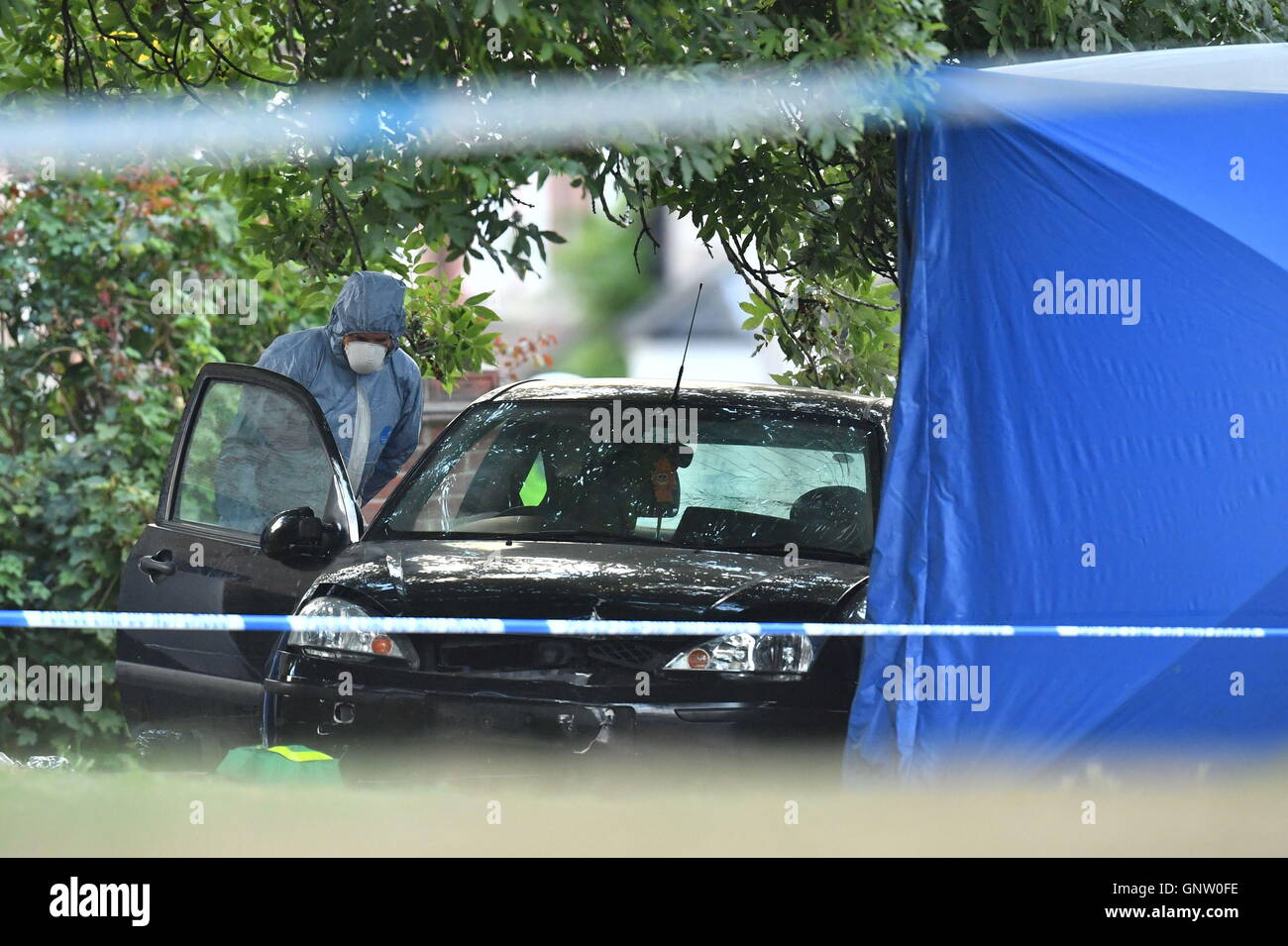 A forensic police officer examines a car at the scene in Lennard Road, Penge in south-east London after a car being chased by police has ploughed into a family leaving two people dead. Stock Photo