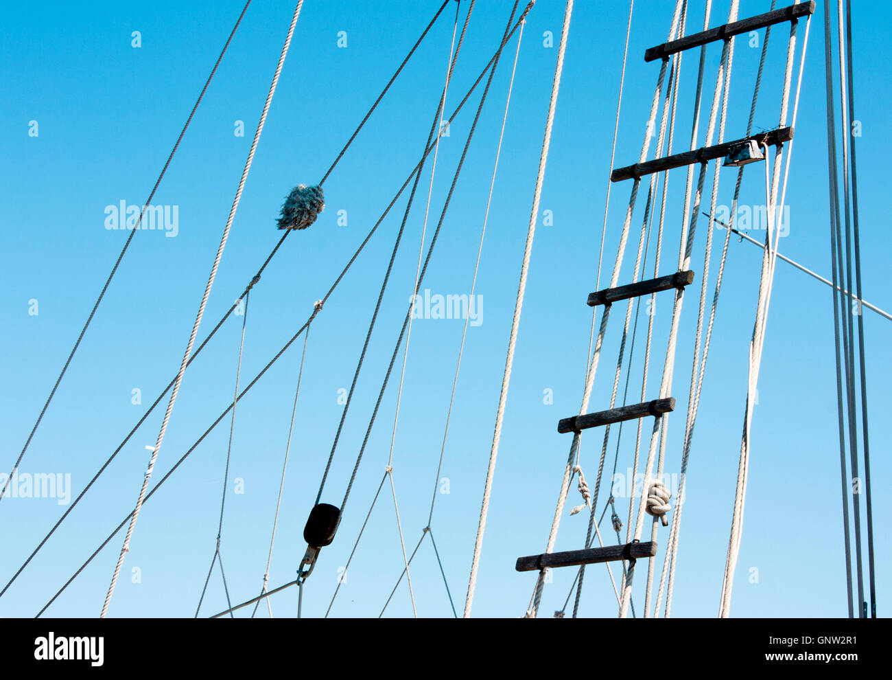 Detail of sailboat rigging and rope ladder against the blue sky Stock Photo