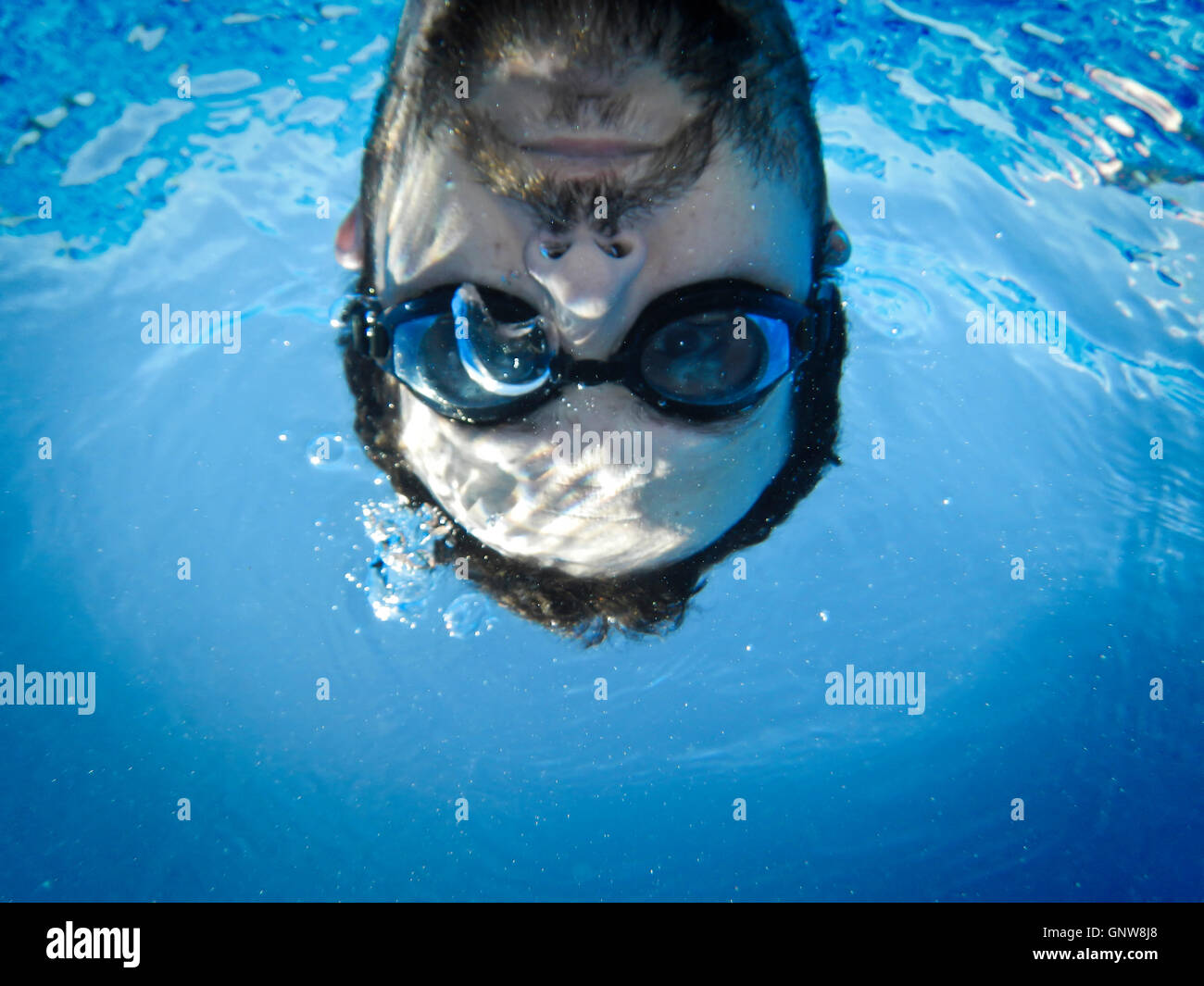 Man face swimming underwater in the pool Stock Photo