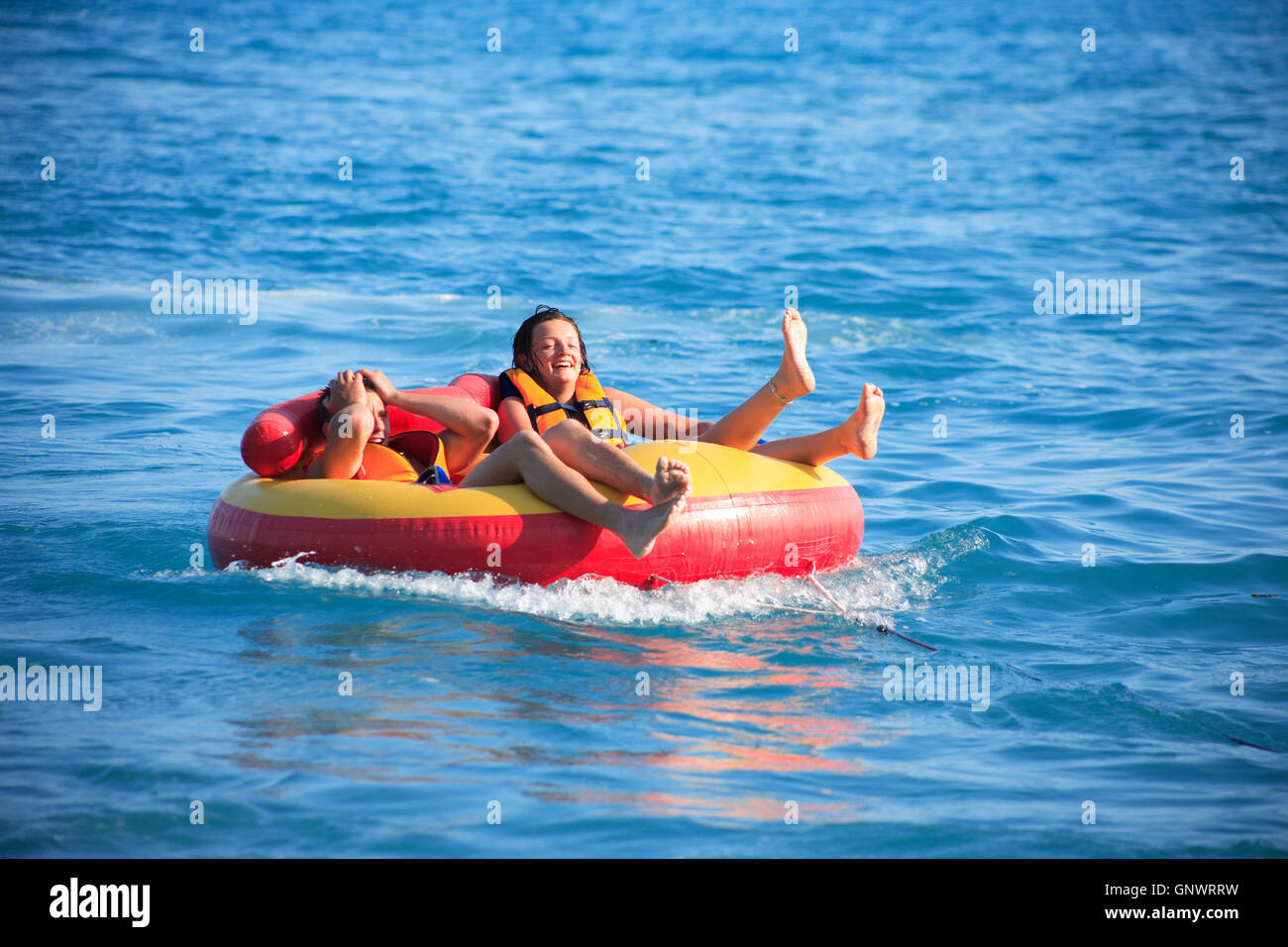 Friends Tubing On Sea Stock Photo