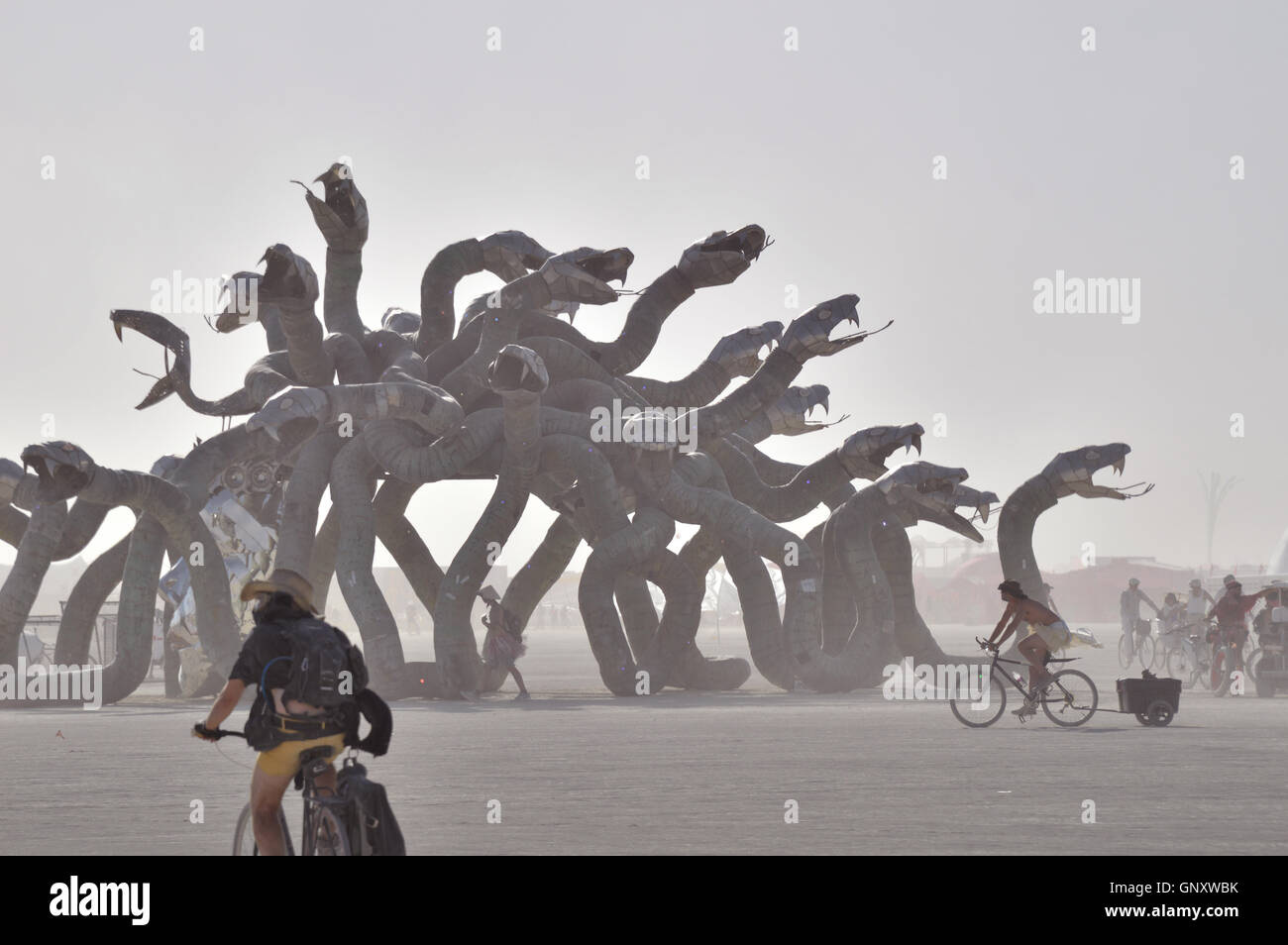 Burners ride past the Medusa Madness art installation during a dust storm at the annual desert festival Burning Man August 30, 2016 in Black Rock City, Nevada. Stock Photo