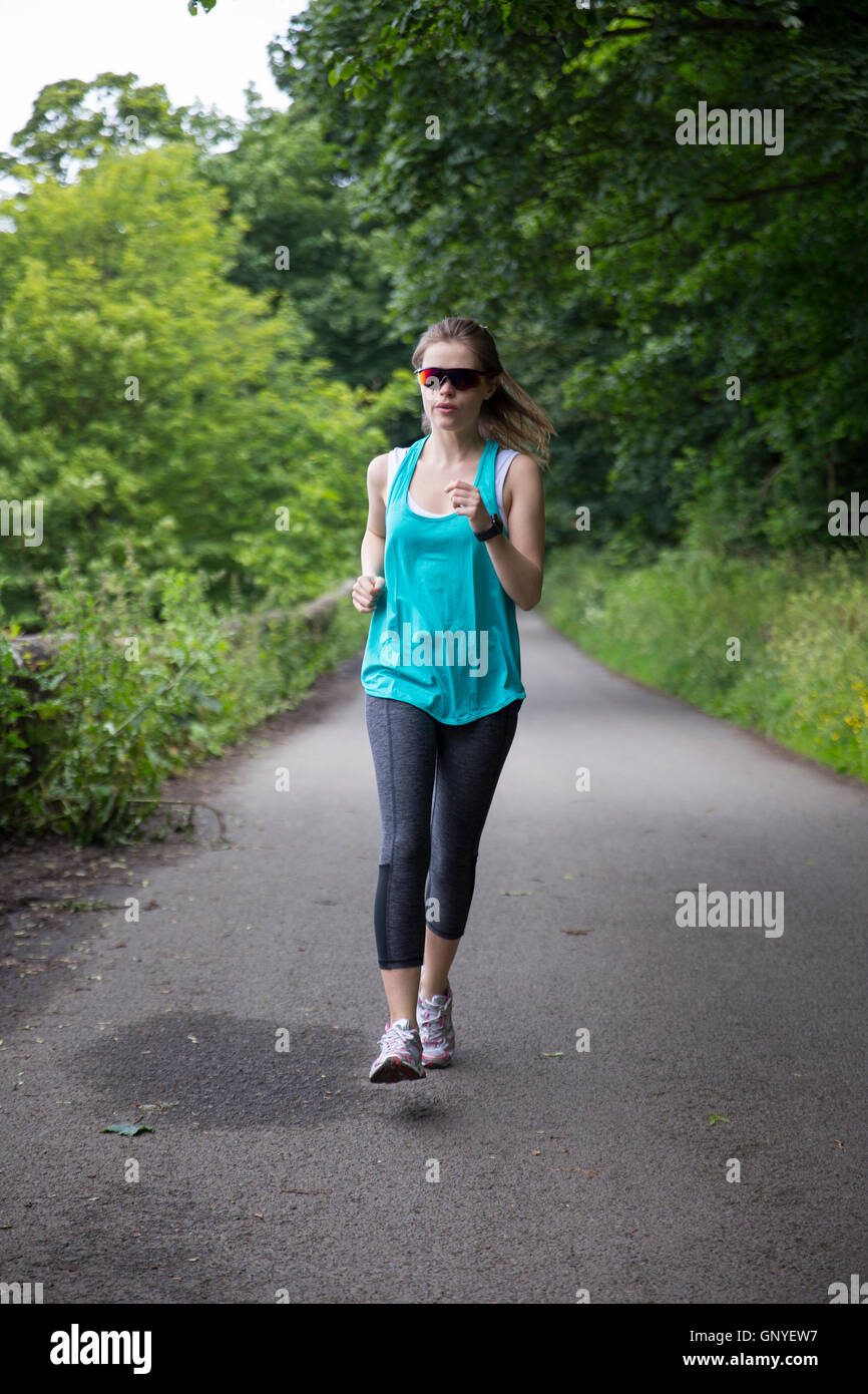 Attractive young woman running outdoors. Action and healthy lifestyle concept. Stock Photo