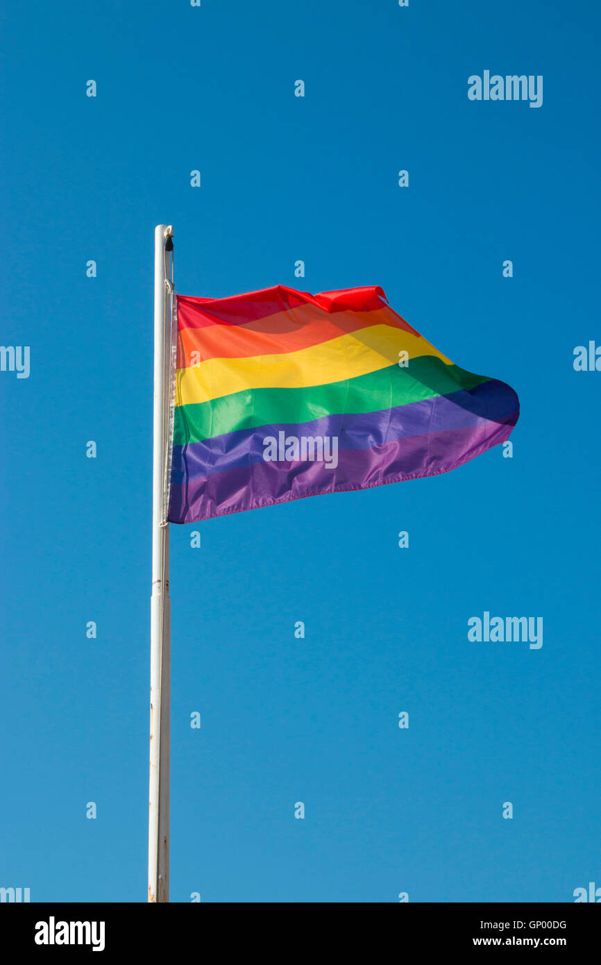 Iconic rainbow LGBTQ Pride flag against blue sky Stock Photo - Alamy