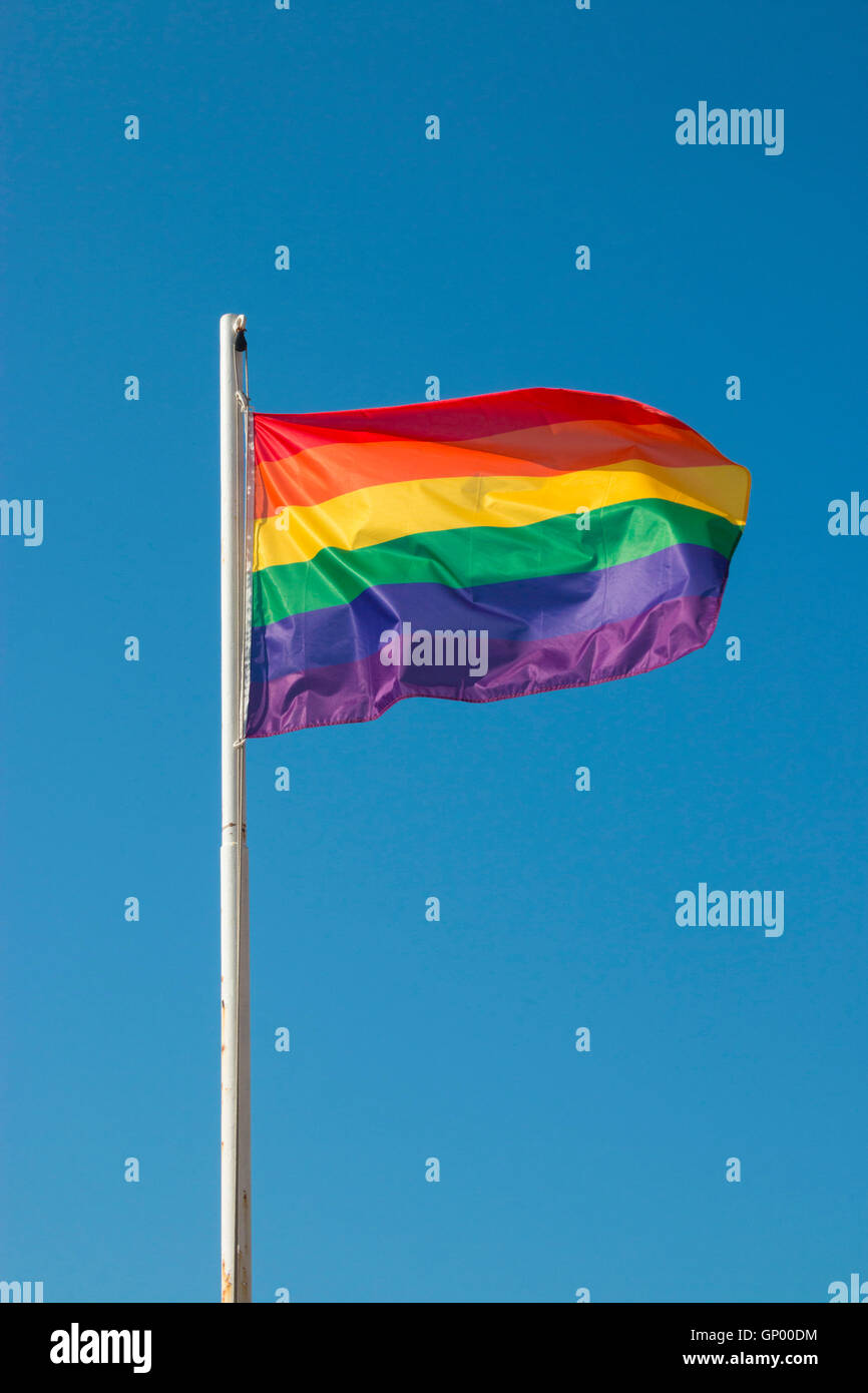 Iconic rainbow LGBTQ Pride flag against blue sky Stock Photo - Alamy