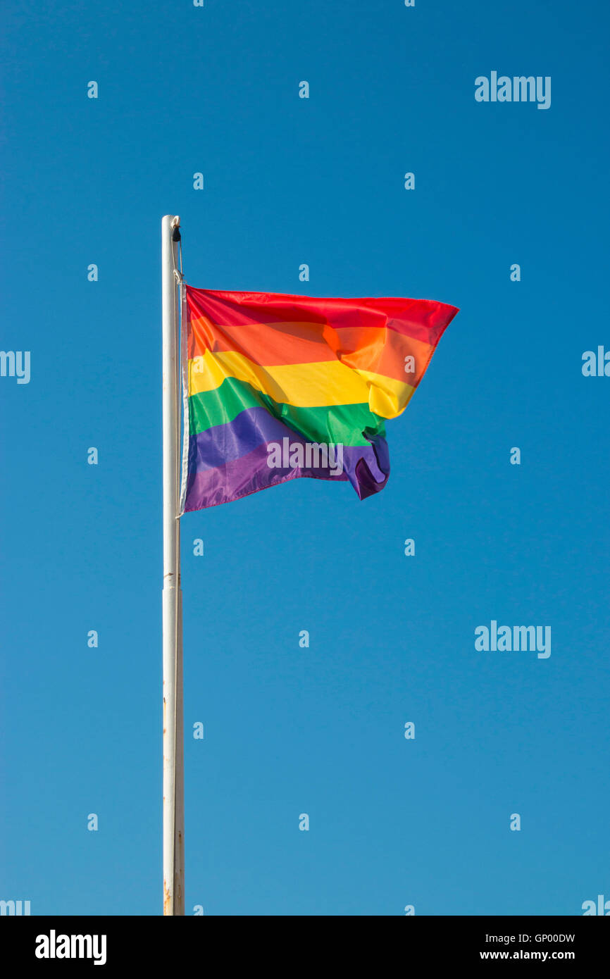Iconic rainbow LGBTQ Pride flag against blue sky Stock Photo - Alamy