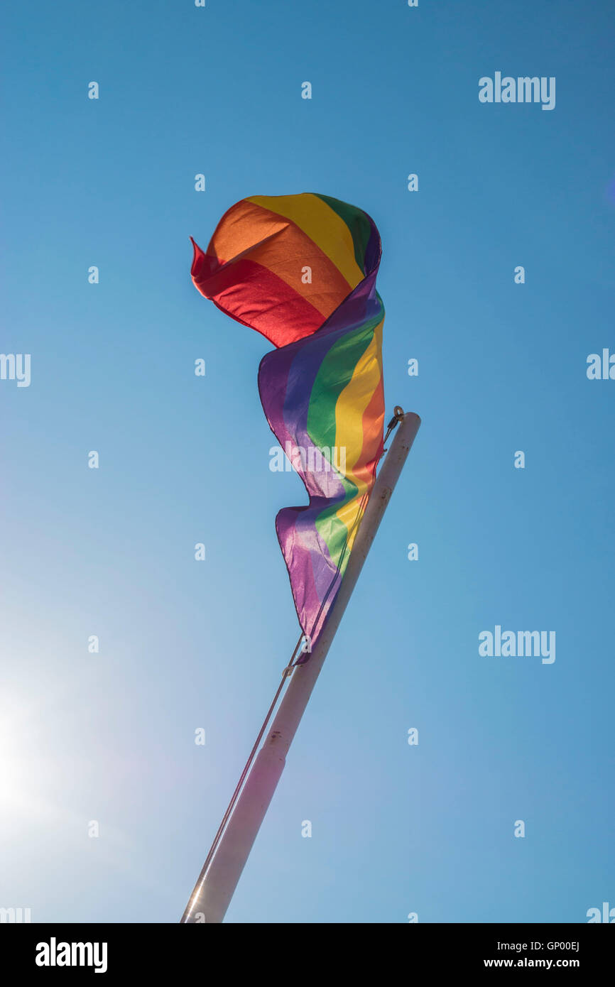 Iconic rainbow LGBTQ Pride flag against blue sky Stock Photo - Alamy
