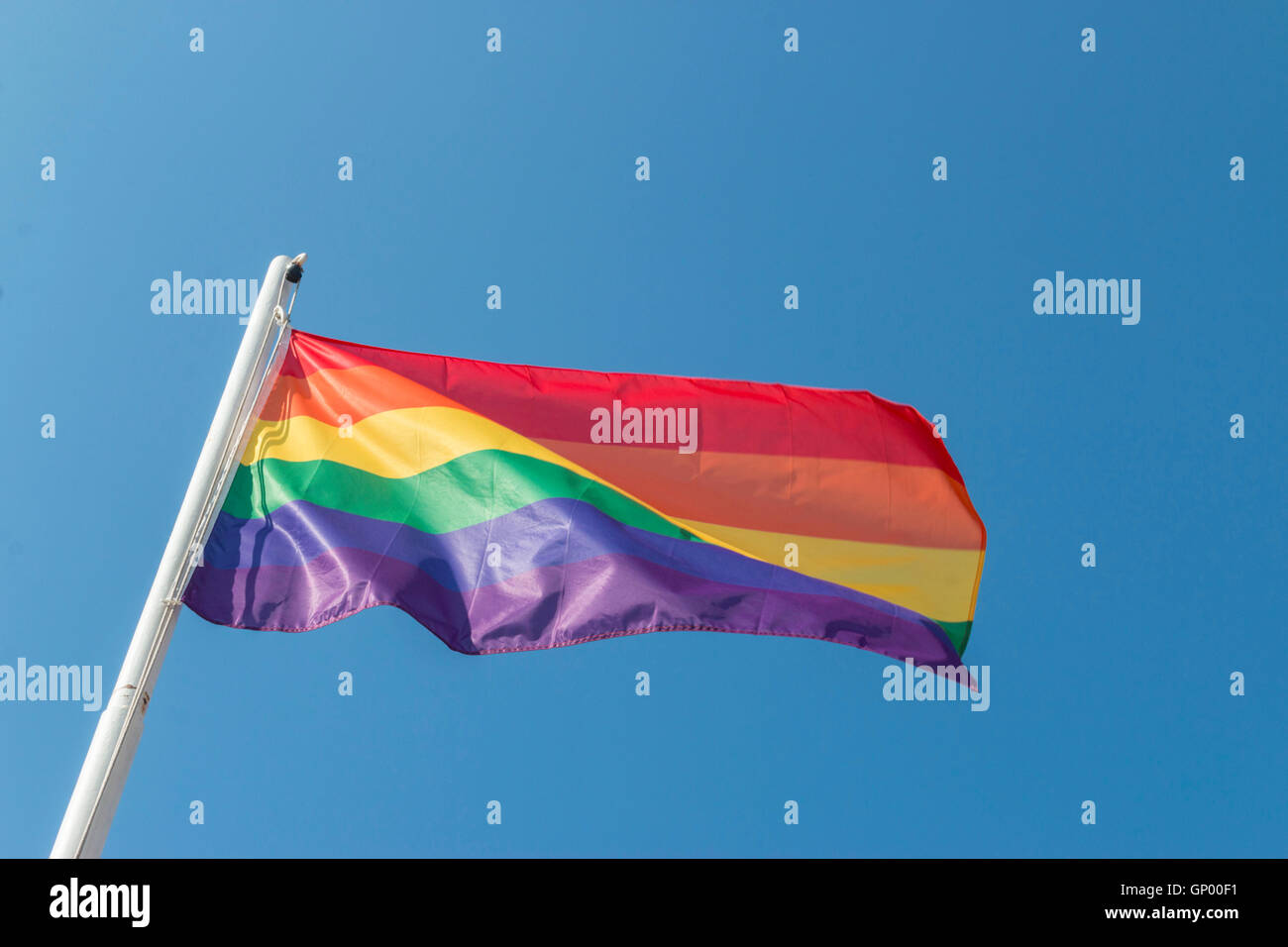 Iconic rainbow LGBTQ Pride flag against blue sky Stock Photo - Alamy