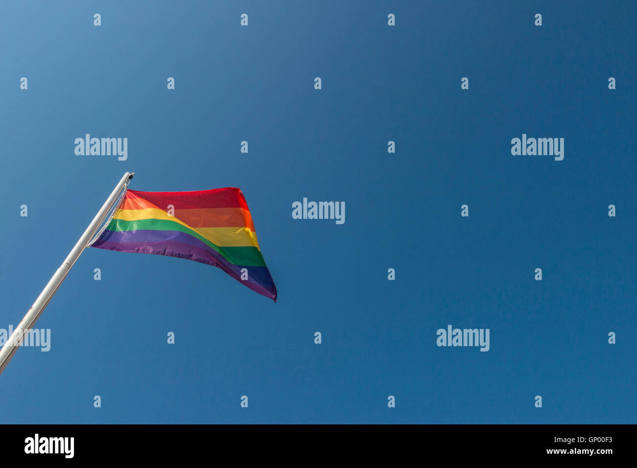Iconic rainbow LGBTQ Pride flag against blue sky Stock Photo - Alamy