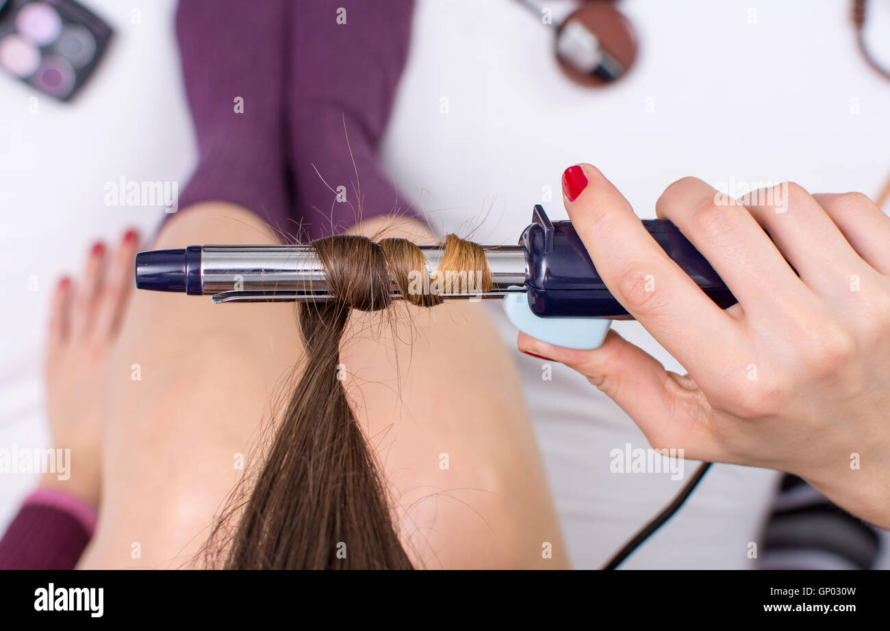 Woman using curling iron on her hair point of view Stock Photo