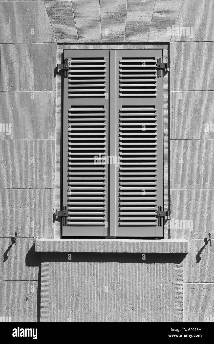Window with closed shutters in direct sunlight. Stock Photo