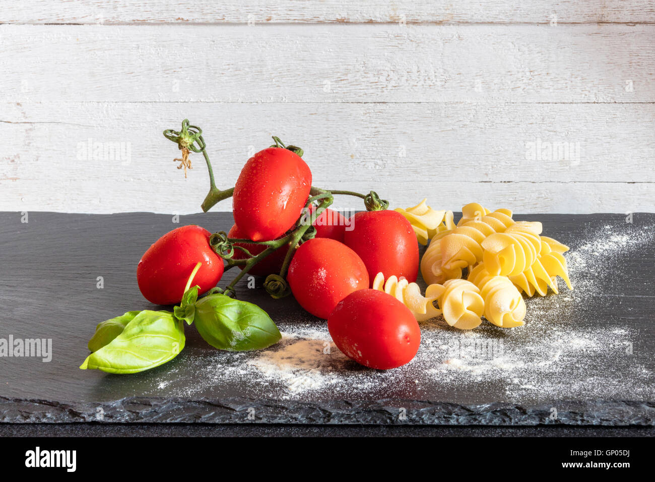Fusilli fresh tomatoes and basil the ingredients for a  typical dish of Italian pasta Stock Photo