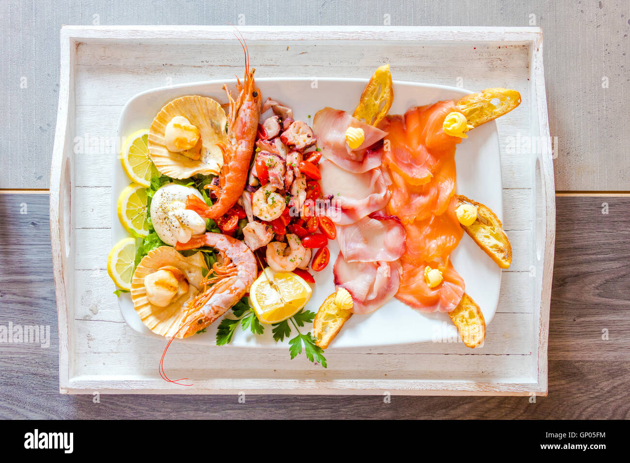 Fresh crayfish with salmon and shrimps served with vegetables a healthy dish typical of Italian cuisine Stock Photo