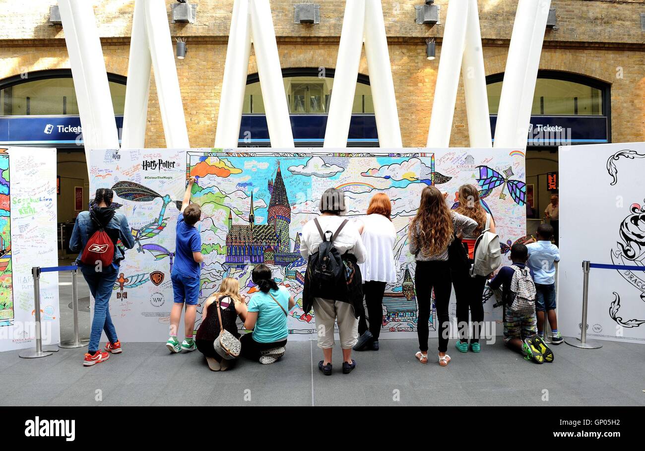 Members of the public and fans of the Harry Potter series fill in Potter-themed colouring boards at Kings Cross station in London. September 1st marks the day when students board the Hogwarts Express at Platform 9 3/4 at King's Cross to return to the fictional Hogwarts school for the new academic year. Stock Photo