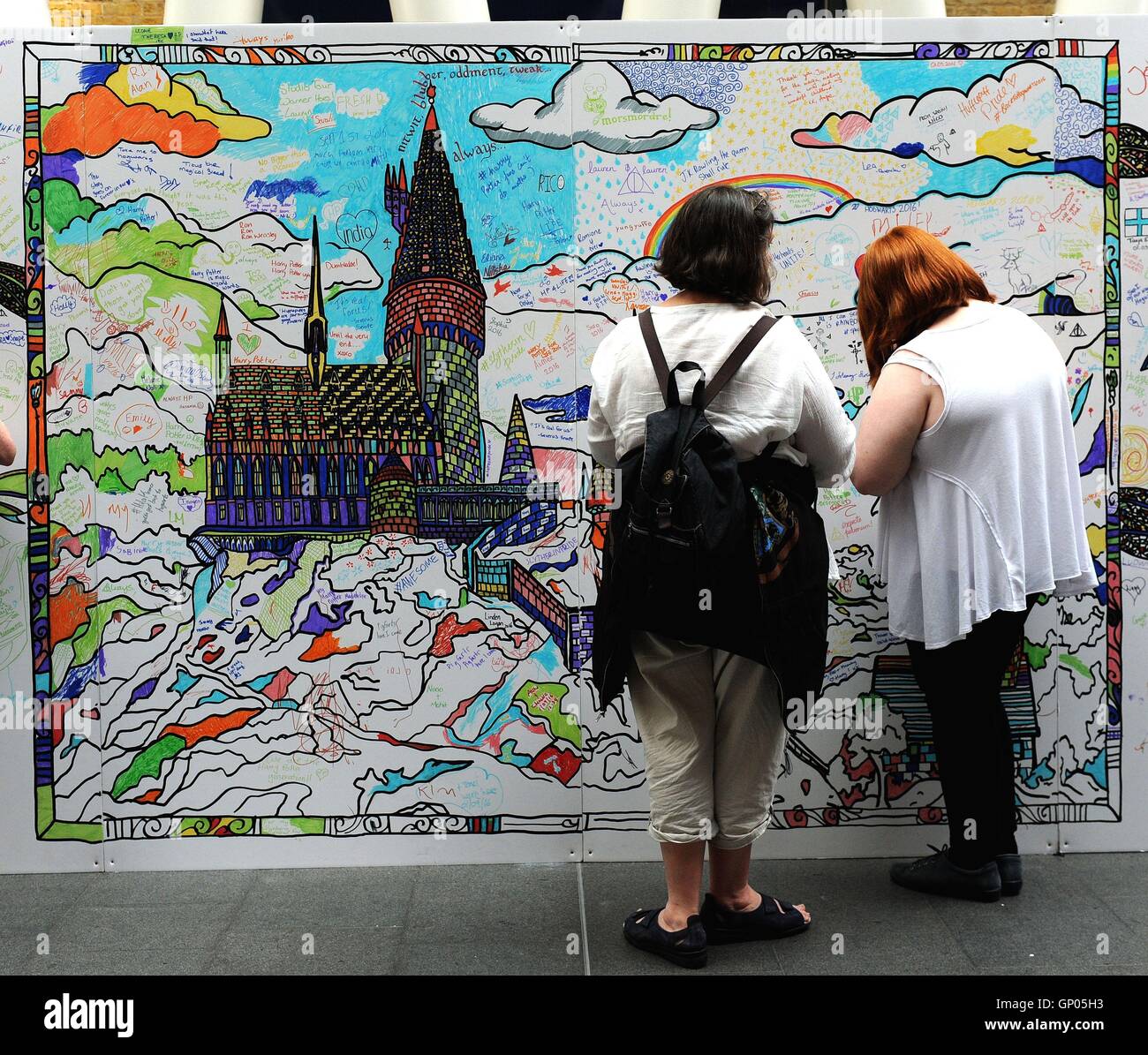 Members of the public and fans of the Harry Potter series fill in Potter-themed colouring boards at Kings Cross station in London. September 1st marks the day when students board the Hogwarts Express at Platform 9 3/4 at King's Cross to return to the fictional Hogwarts school for the new academic year. Stock Photo