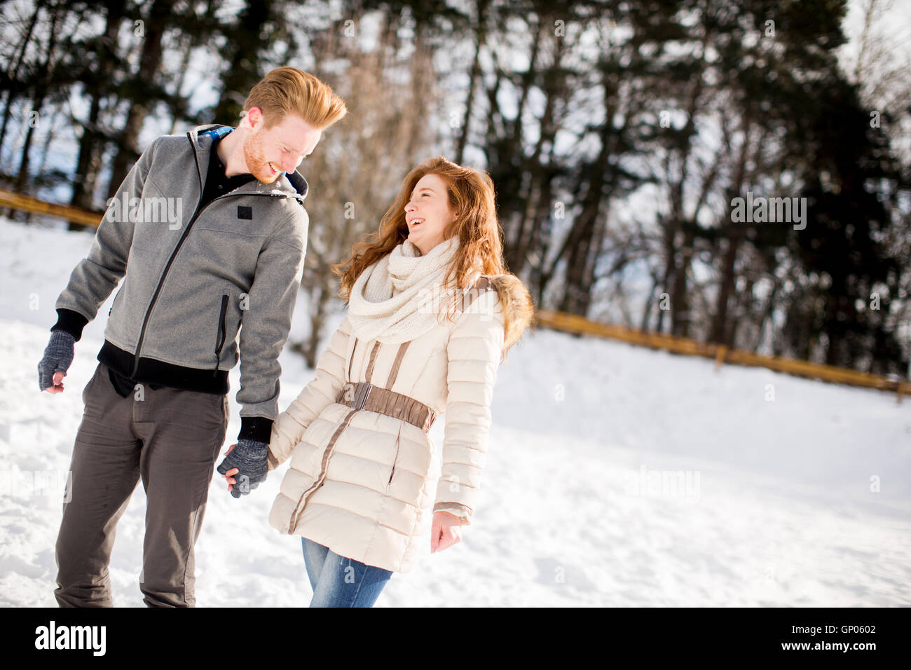 Loving young couple at snow in the winter forest Stock Photo