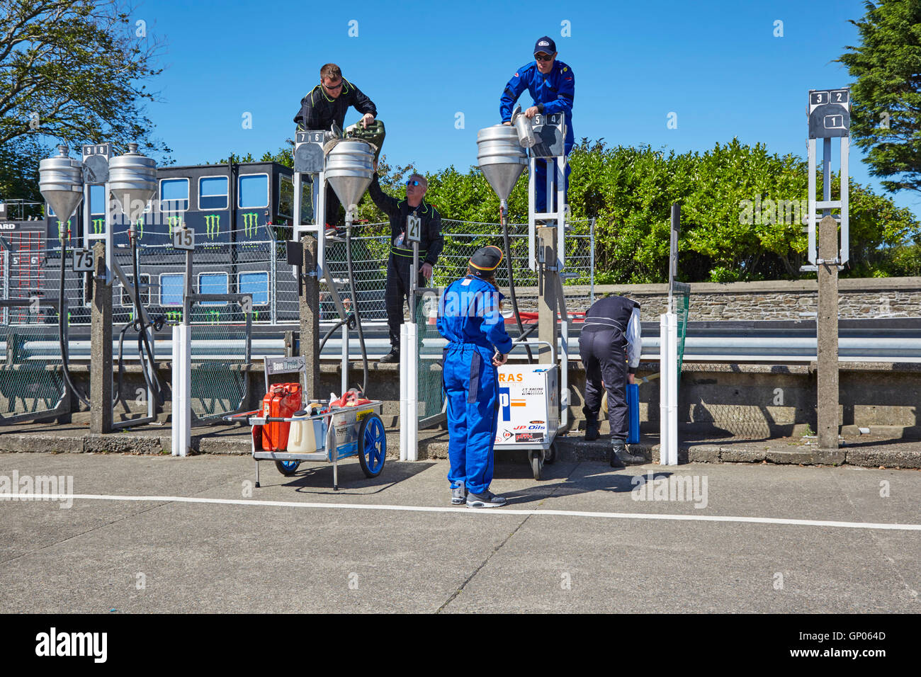 Mechanics pouring fuel at the before the start of the Superbike Classic TT race Stock Photo