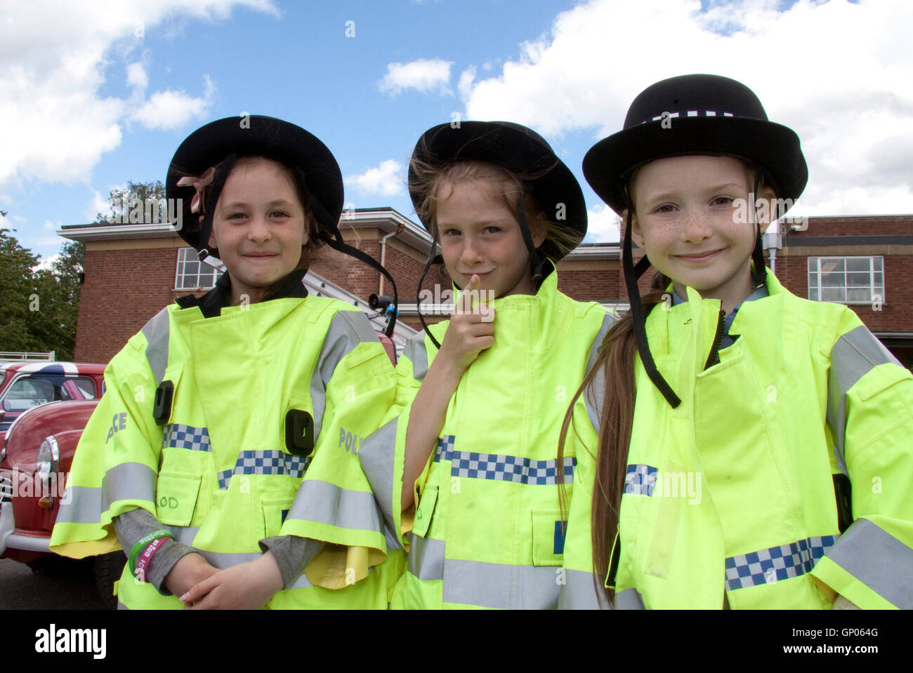 Three little girls at a Suffolk school fete wearing British police uniform Stock Photo Alamy