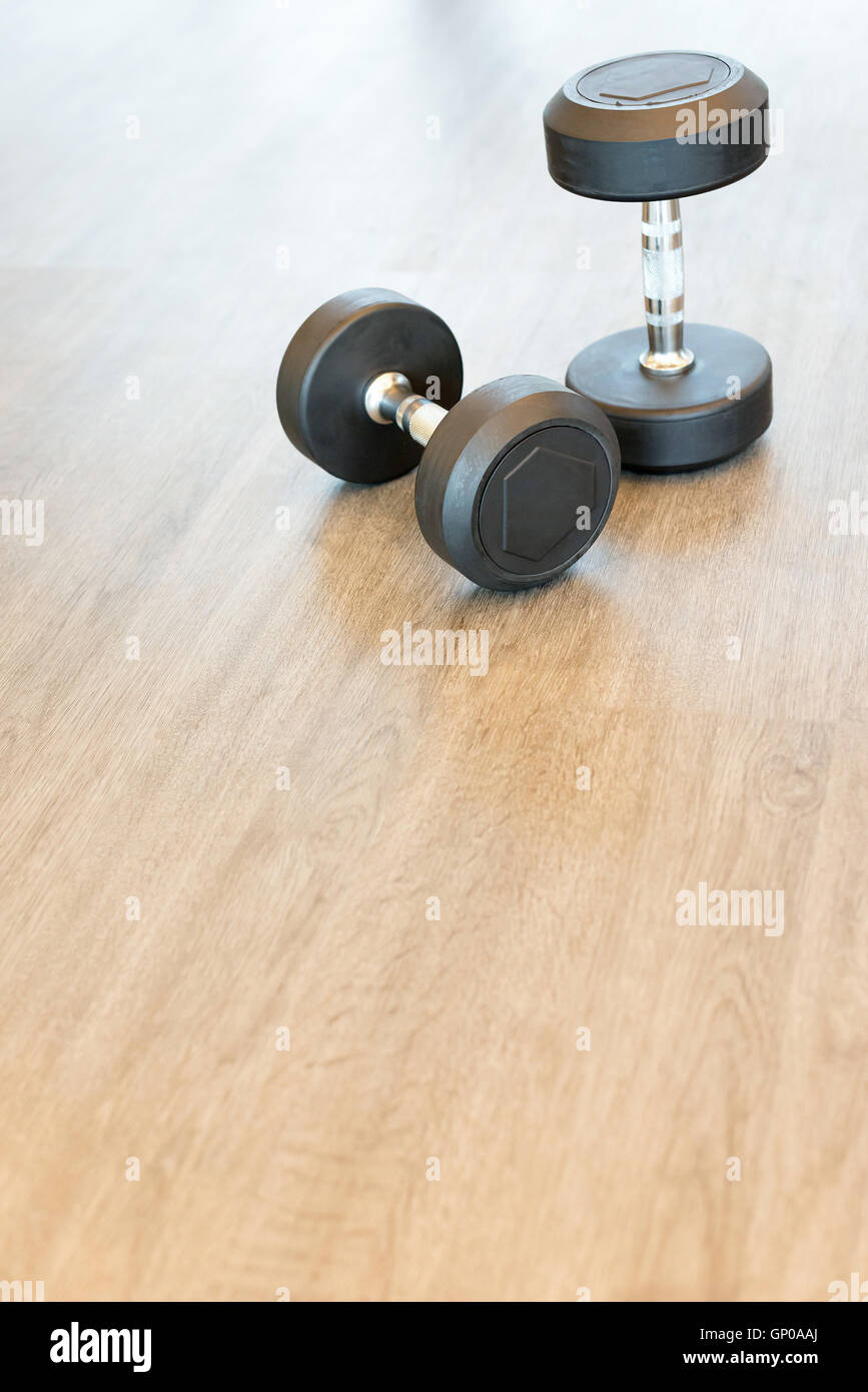Two dumbbells on the floor in a hall, copy space. Stock Photo